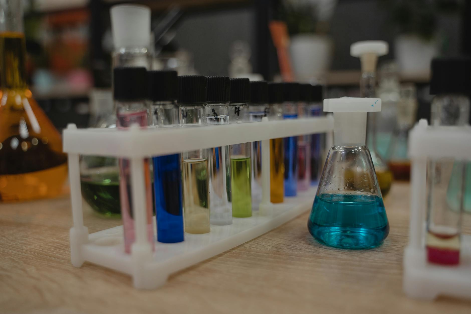 Close-up of colorful test tubes and a digital tablet used for discovery based learning in a chemistry lab.