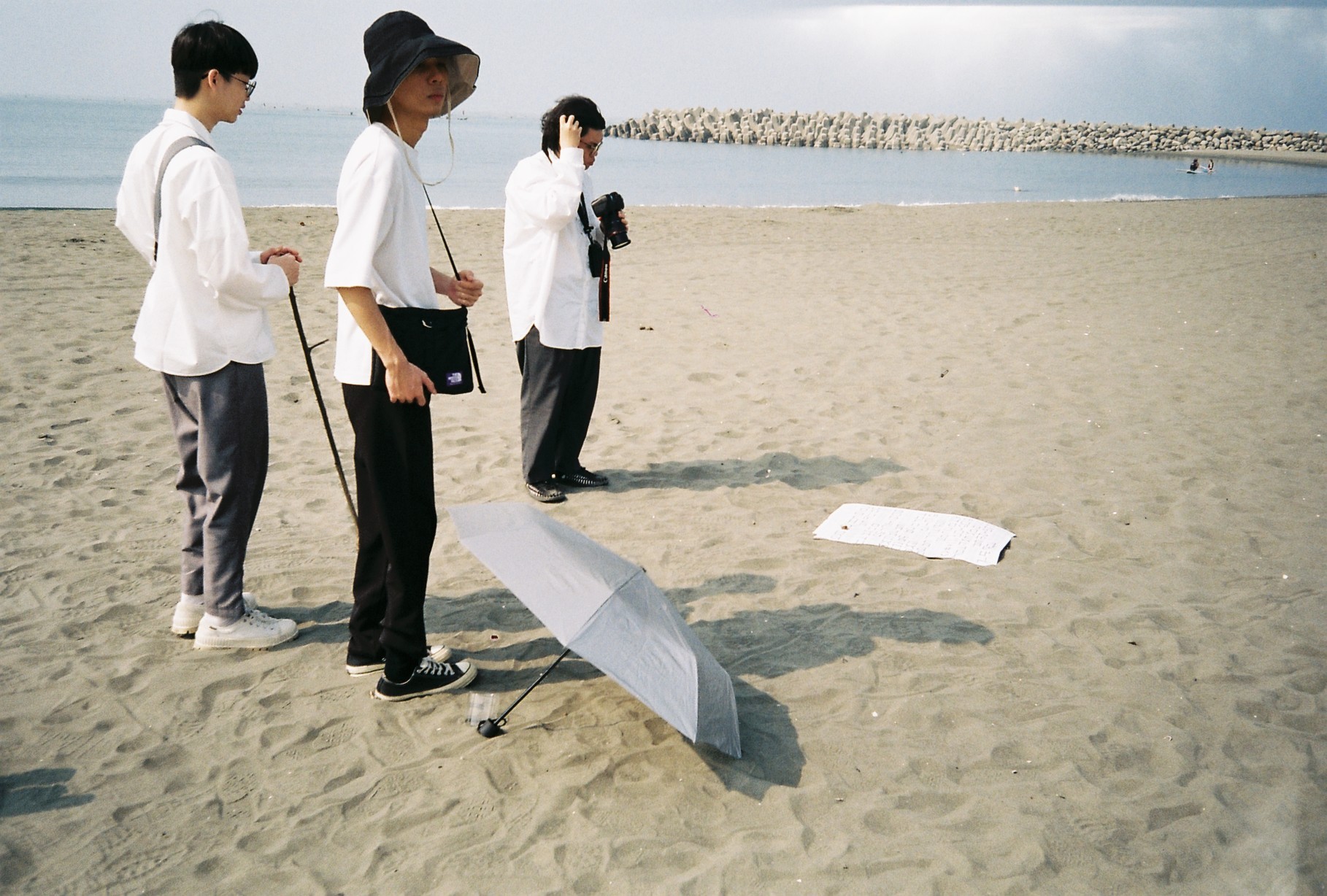 A close-up of a hand wearing multiple decorative rings against a blue background.