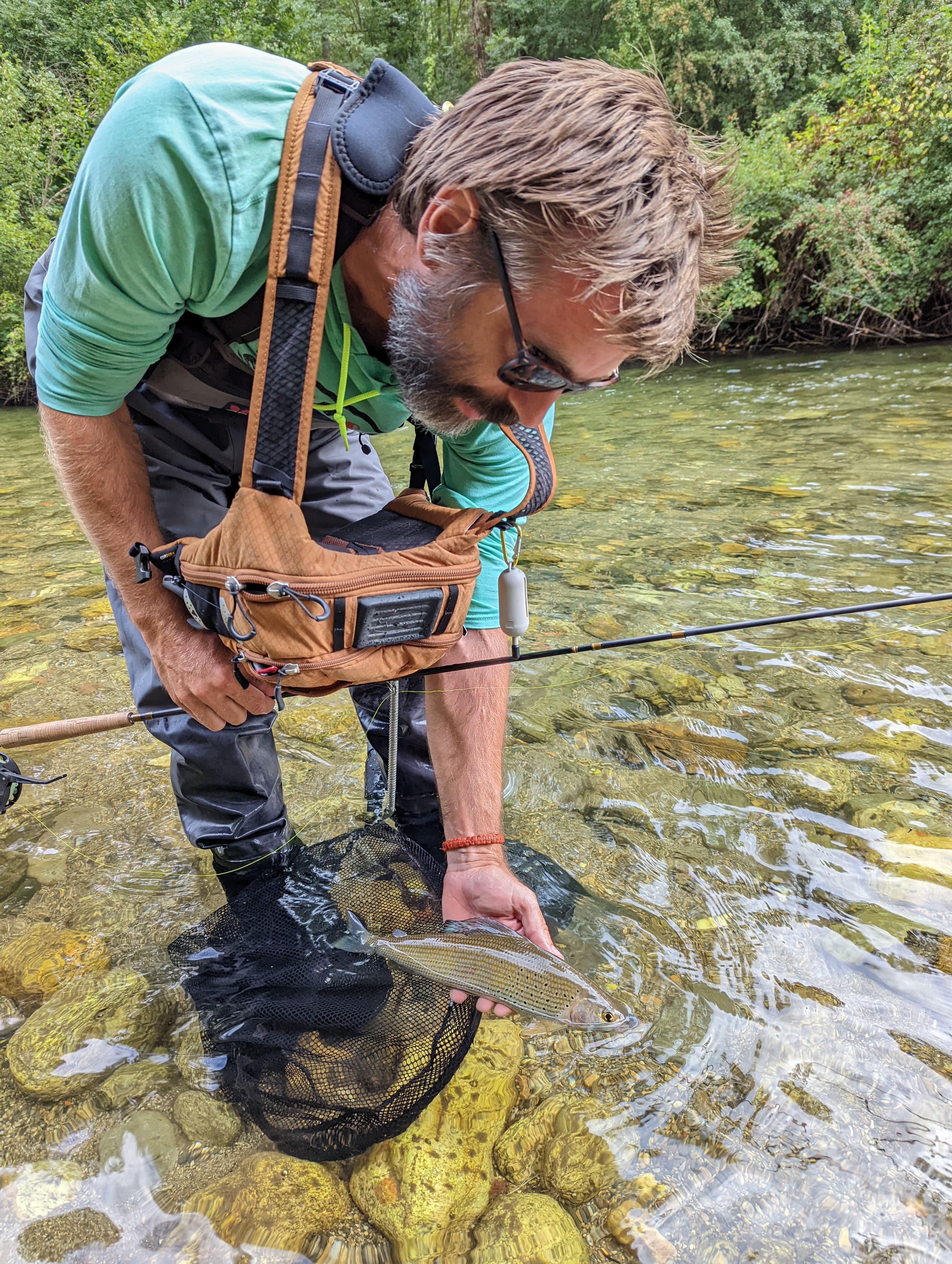 Catch of the day: an angler with a big trout from the Ariège, surrounded by the Pyrenees.