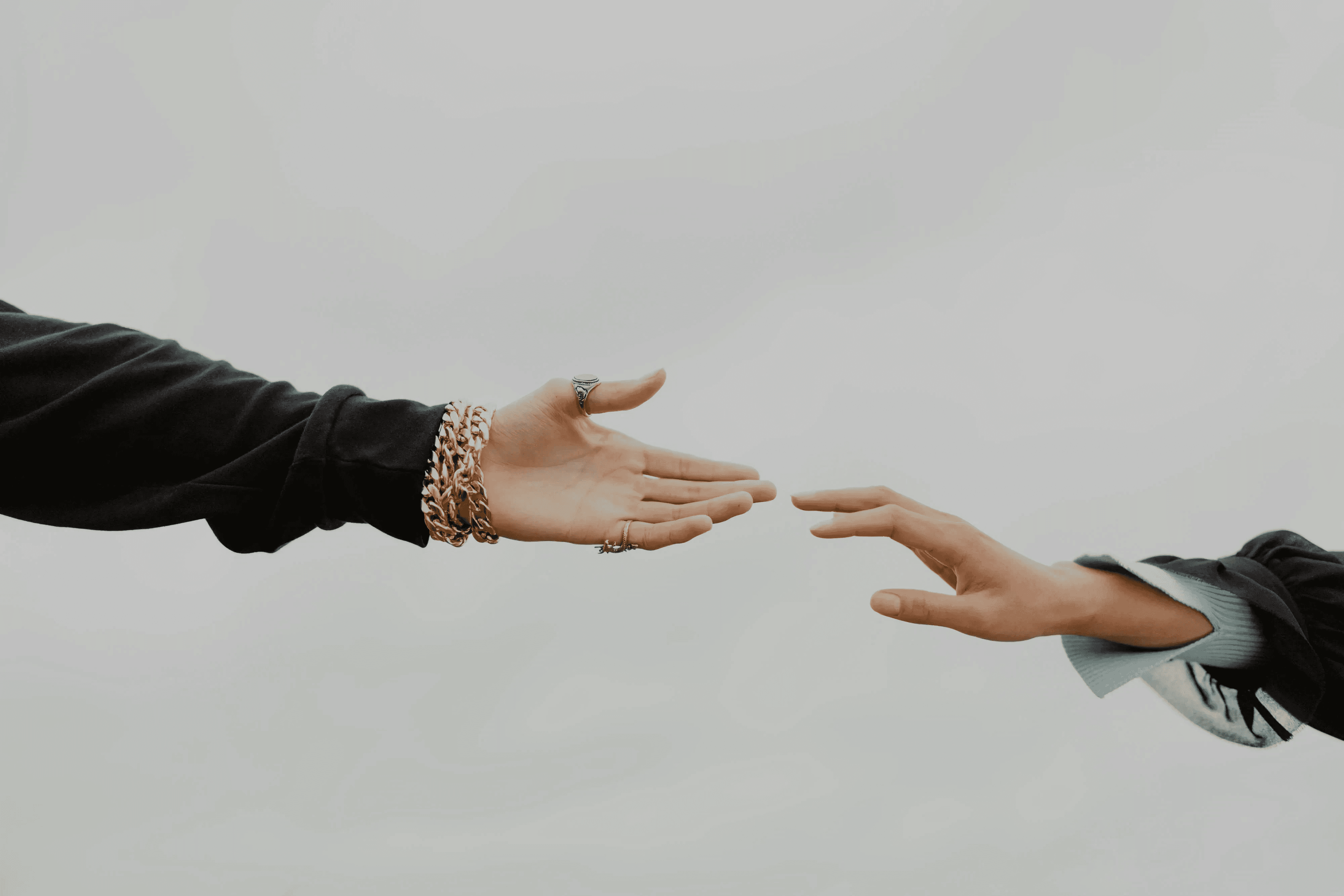 Close-up of two hands reaching toward each other, symbolizing Linqa’s intent-based matching.