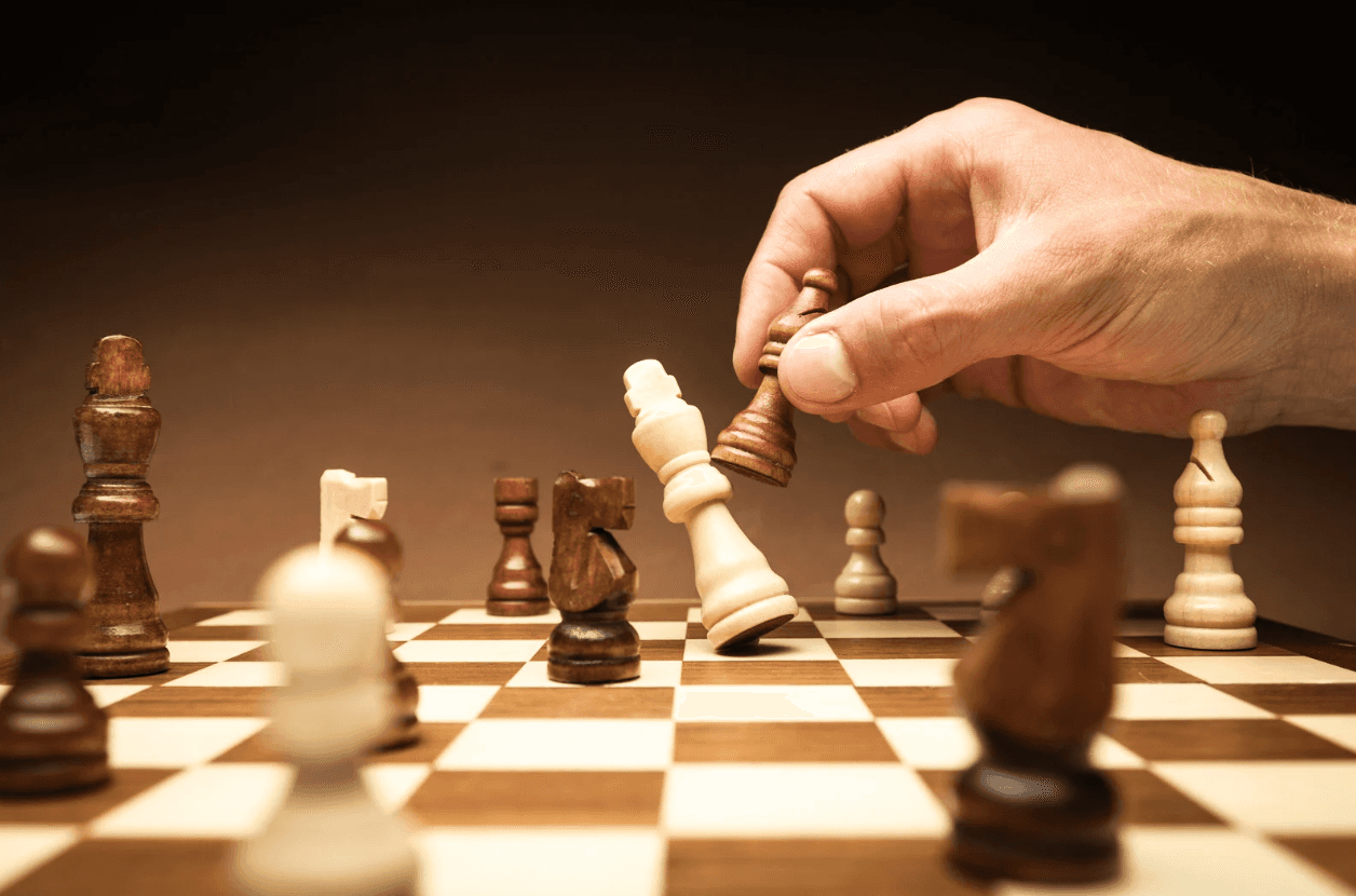 Close-up of a chess move with a king being captured — symbolising strategy, control, and preventing internal campaign competition in Amazon advertising.