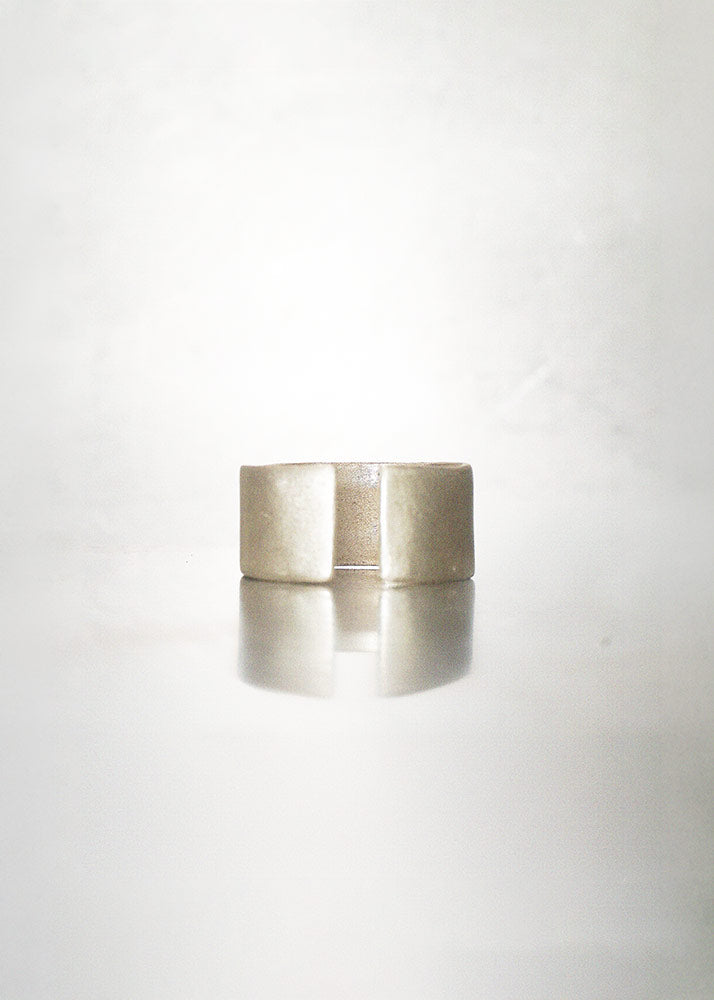 Silver cylindrical ring on a white background