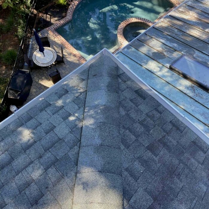 Before and after—downspout flushing showing improved water drainage after professional cleaning.