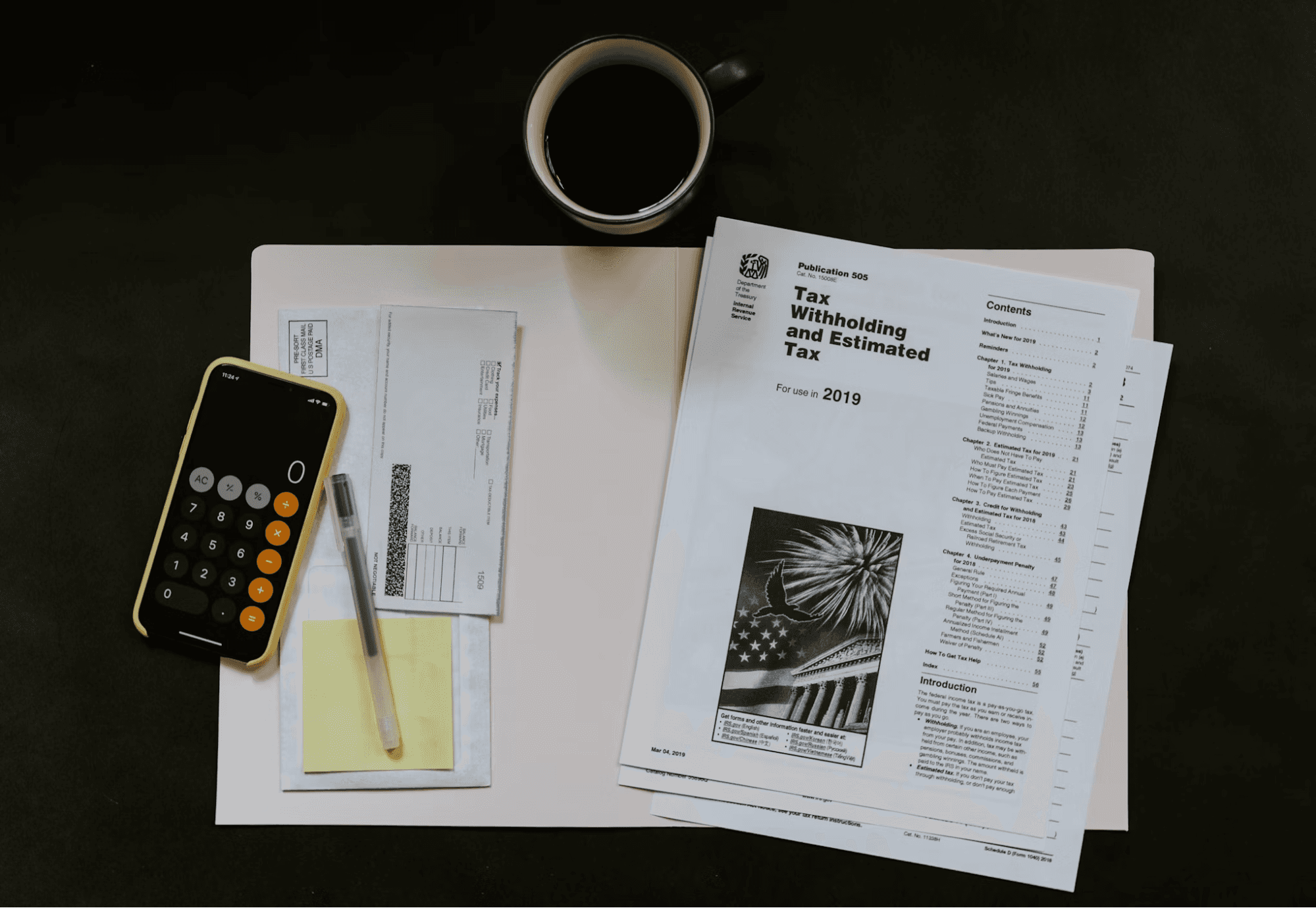 Tax documents, calculator, and coffee on a desk, representing tax preparation for foreign LLC owners.