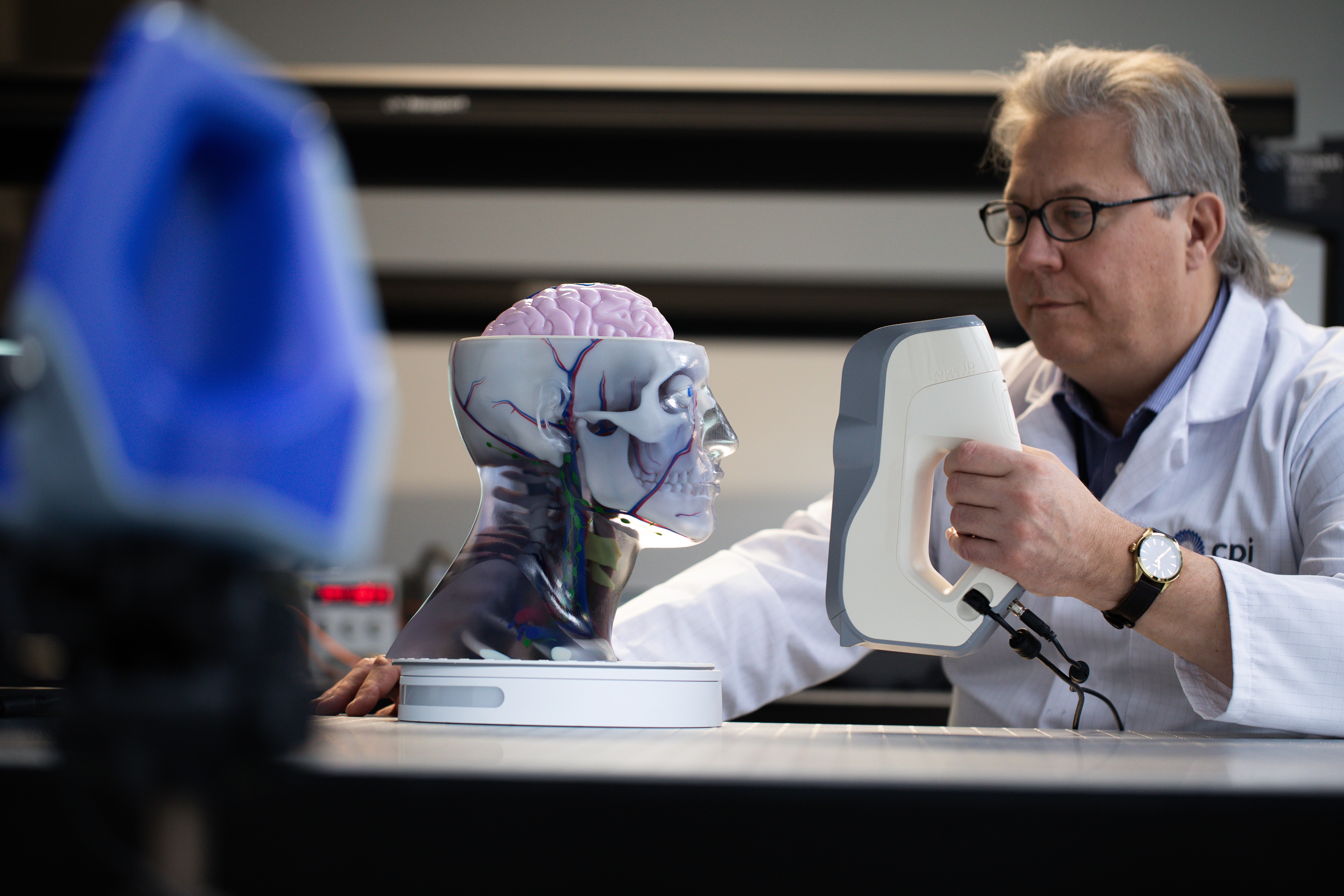CPI scientist holding a device that is scanning a fake human head.