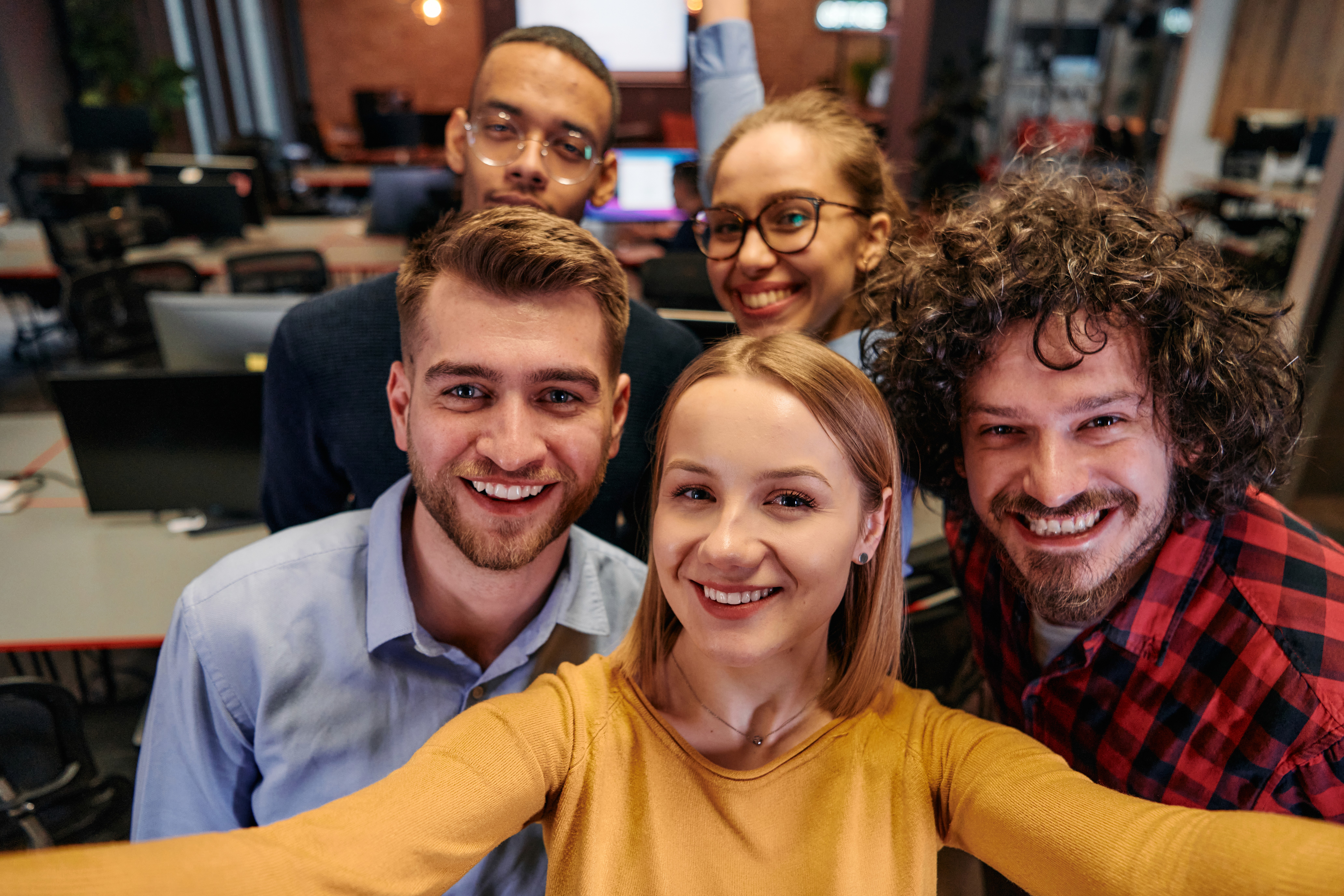Team of three employees having a meeting at a table in a bright modern office.
