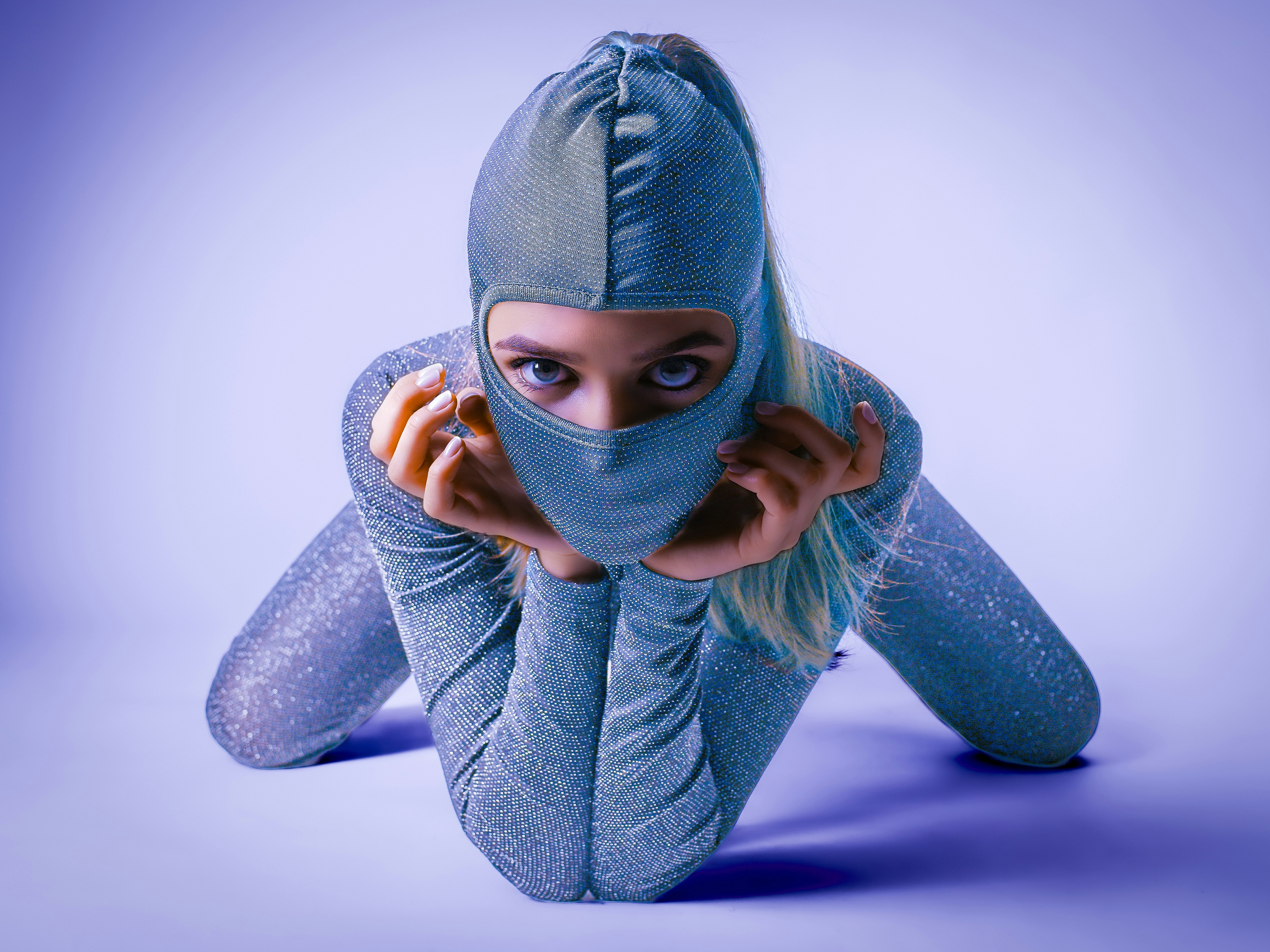 Woman in a shiny silver hooded outfit with mask