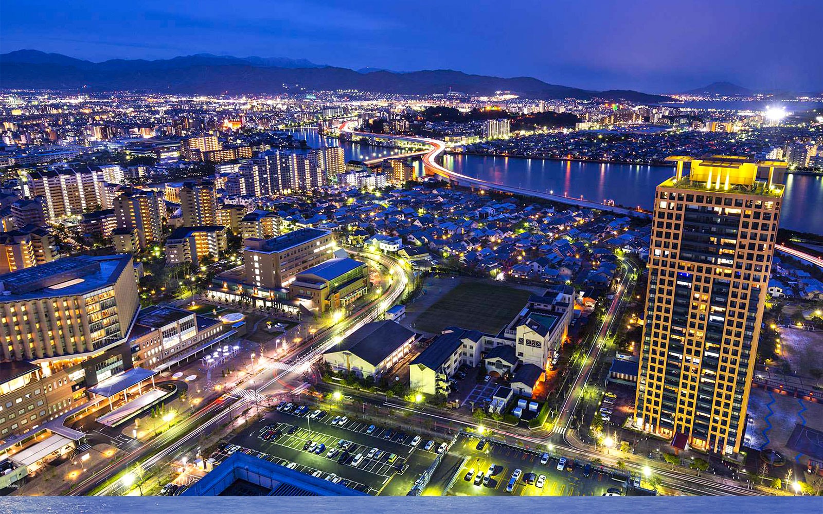 Fukuoka cityscape at night with illuminated buildings and river view from Fukuoka Tower.