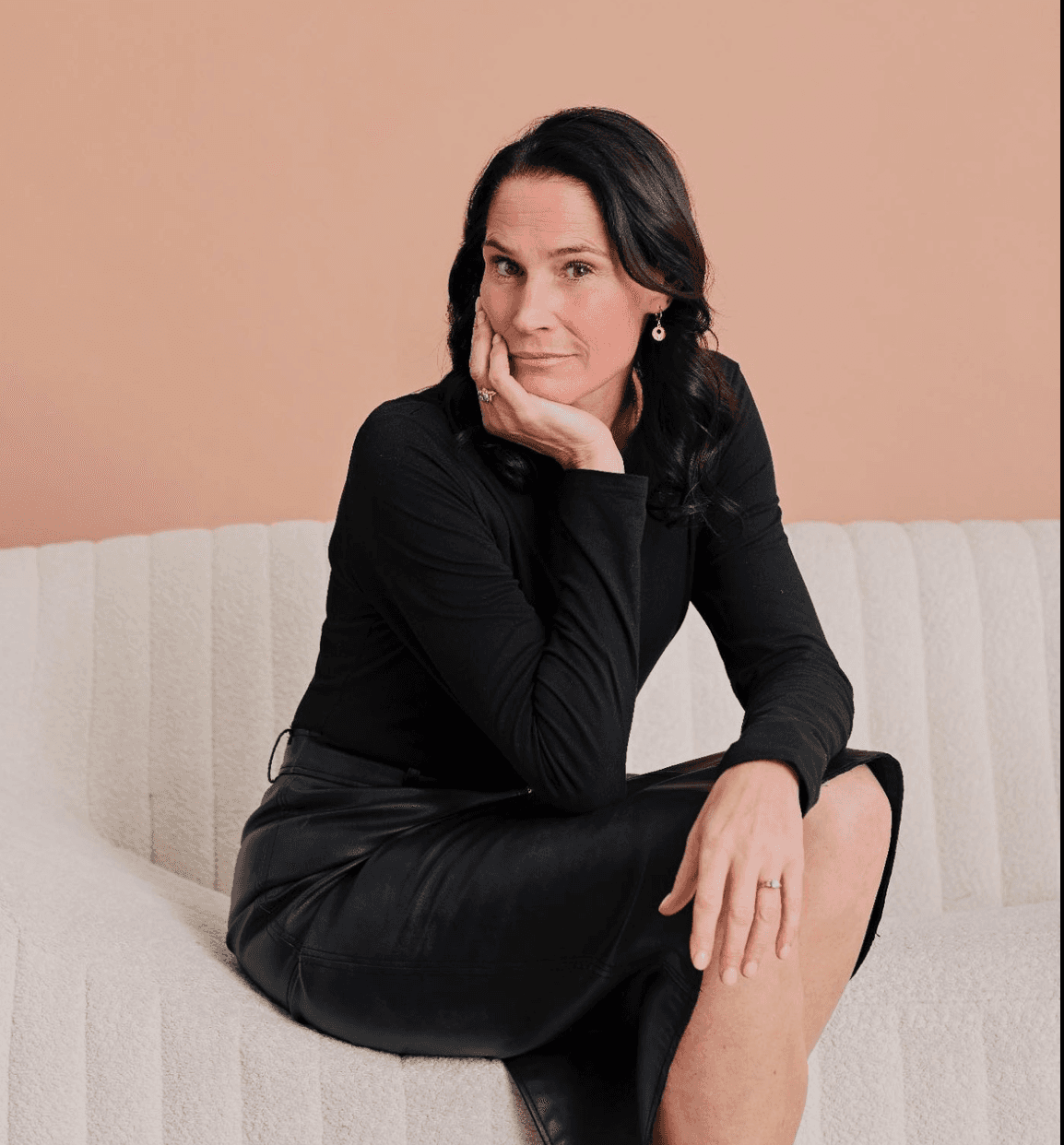 Personne assise sur un canapé clair, posant la tête sur sa main