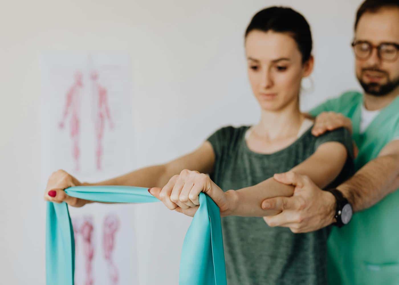 A chiropractor helping a woman with her posture by extending her arms