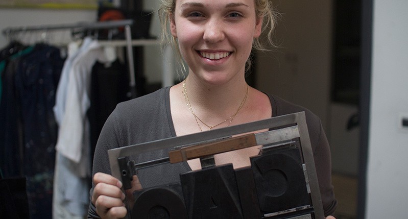 a woman holdingg a metal letter