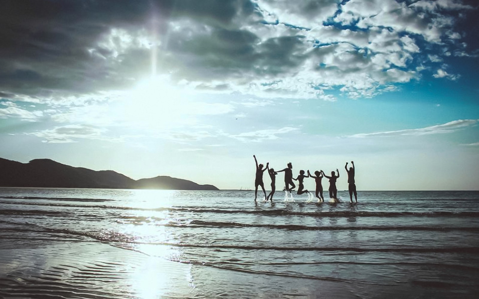 Group enjoying sunset on Okinawa beach during Hip Hop Bus Tour.