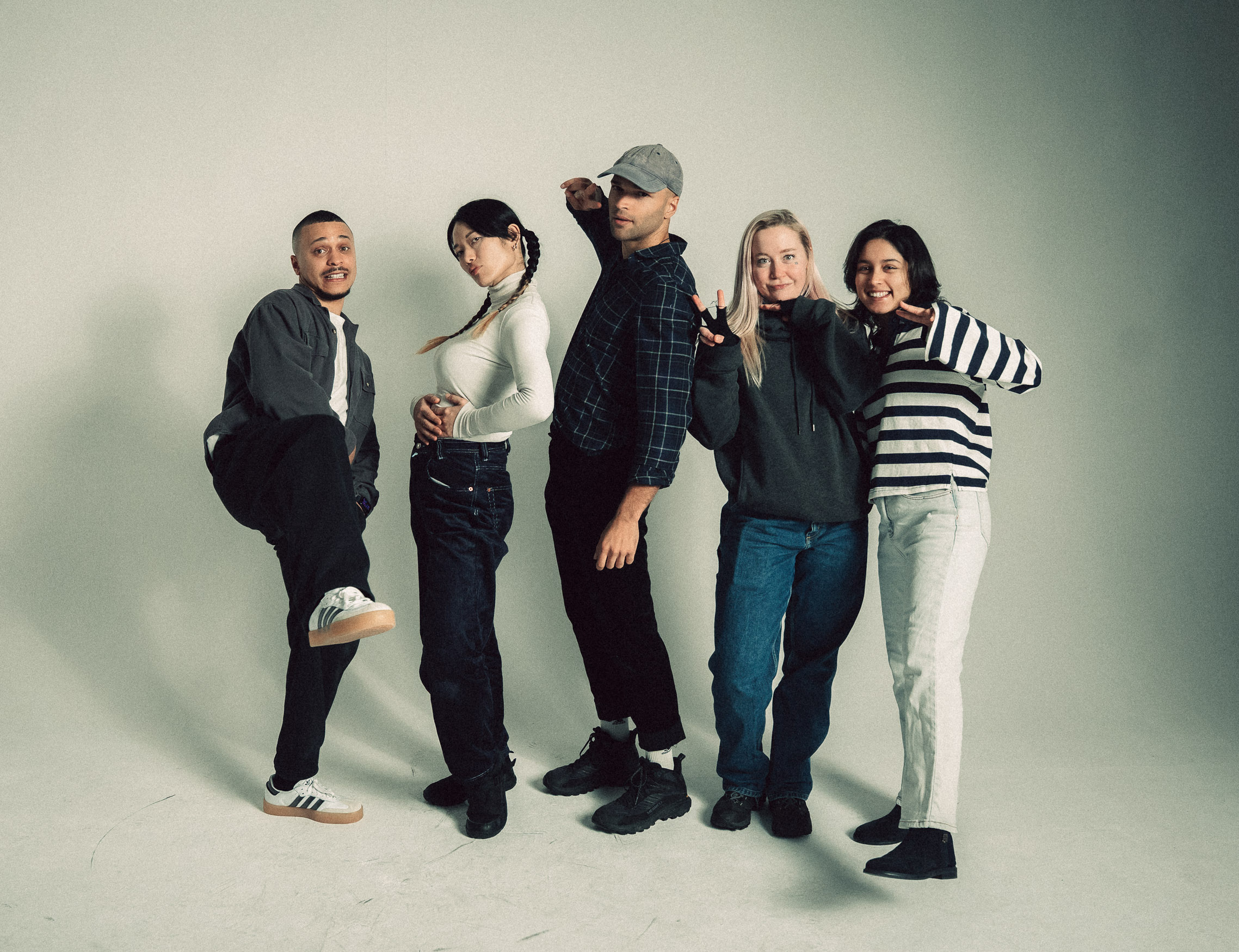 Three people in conversation with warm lighting, including a person wearing a hat and another person wrapped in what appears to be a textured shawl or sweater.