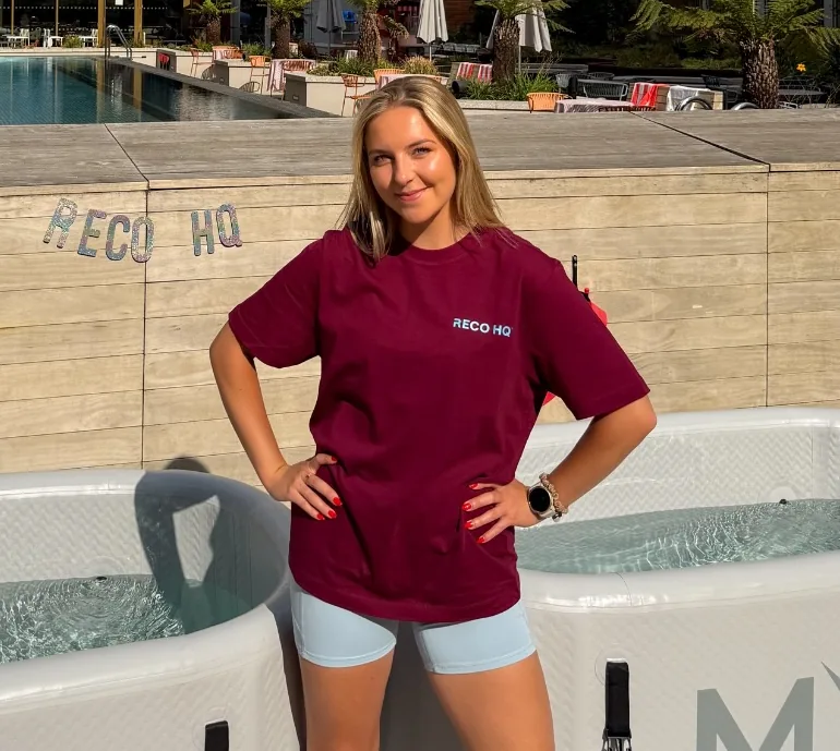 A woman in a RECO HQ T-shirt standing beside the ice baths