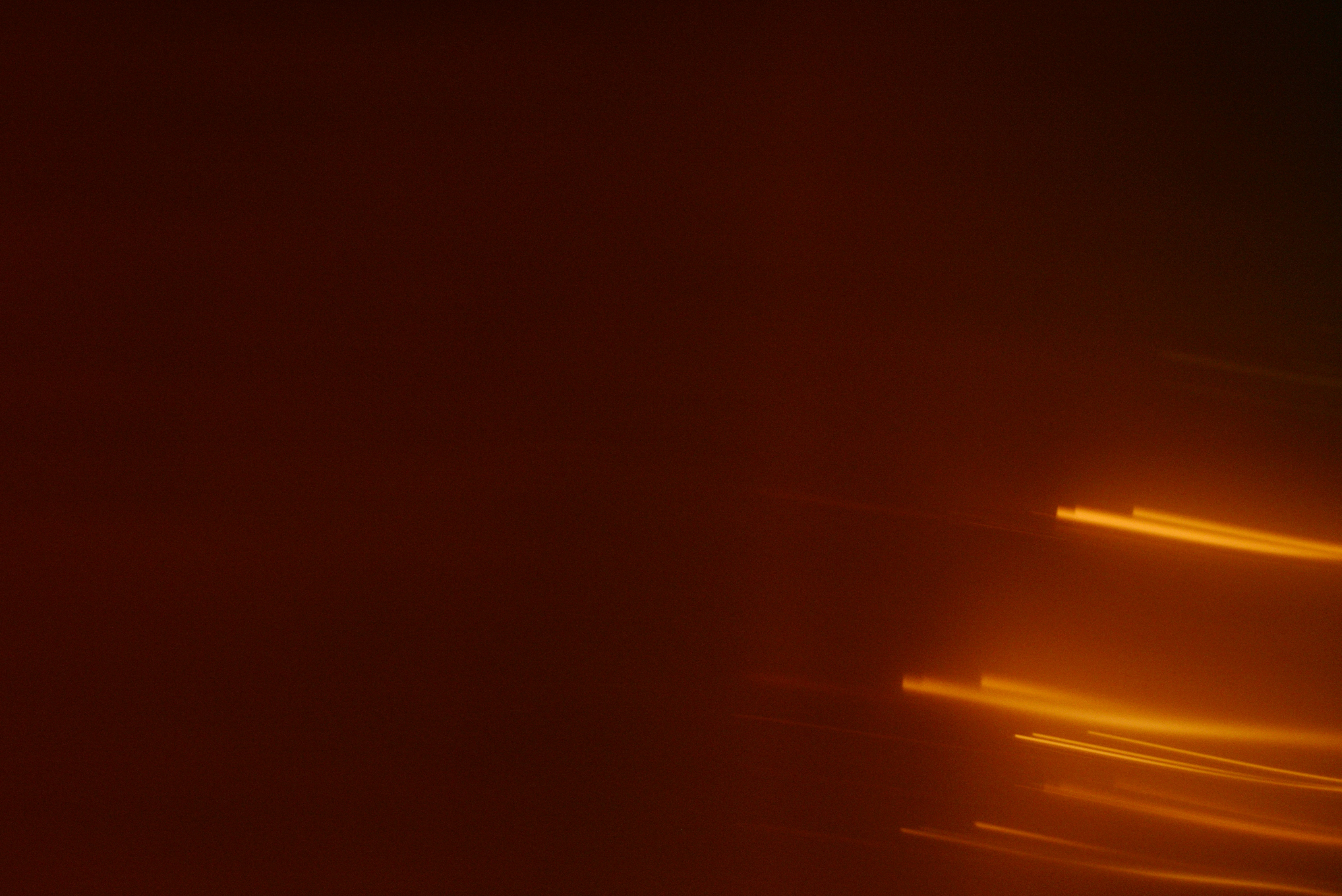 Abstract streaks of orange light on dark background.