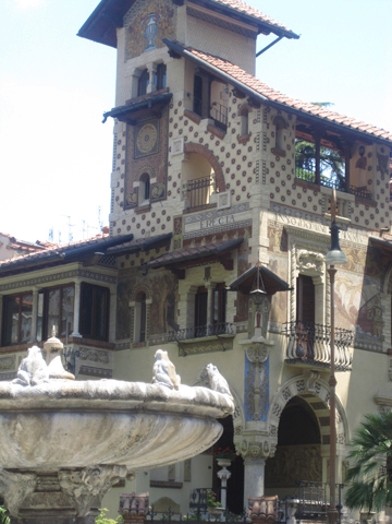 A photo of a house with mosaics and white and brown squares on its walls.