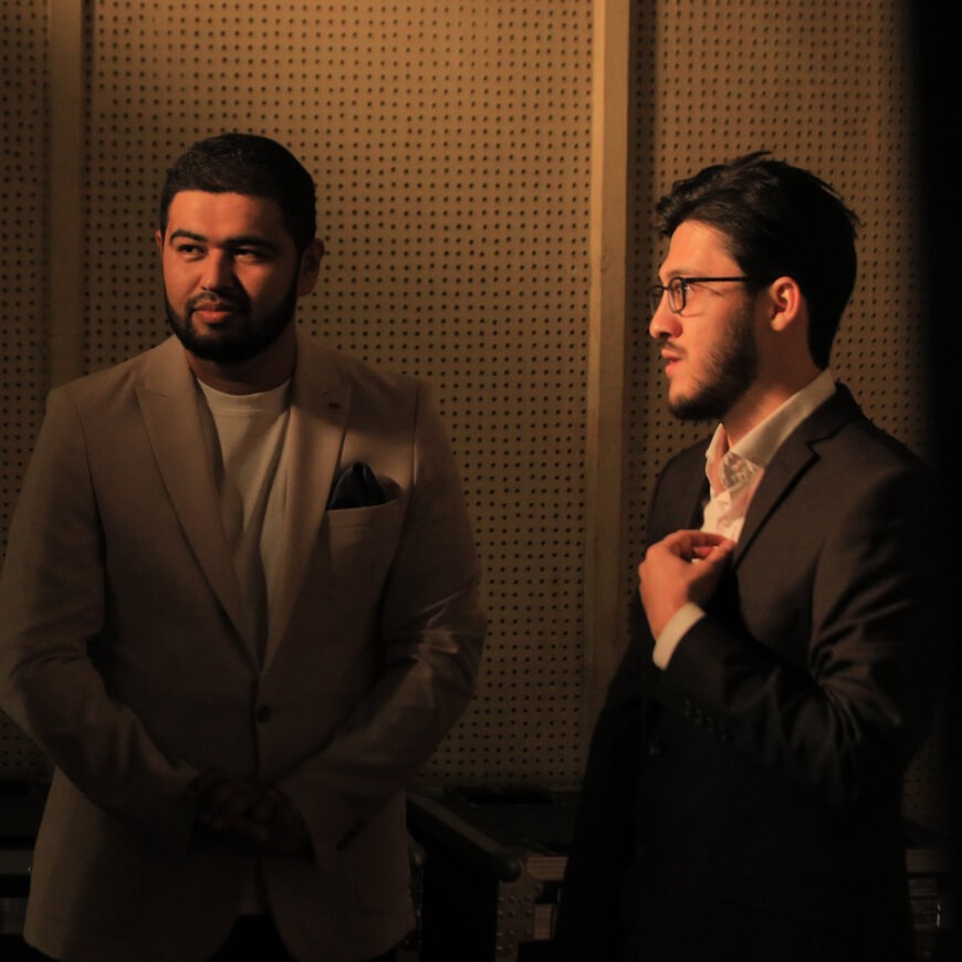 A series of images from Lola Animation's presentation at the Alisher Navoiy Kinochilar Uyi, showcasing a large Lola Animation Studio banner with cartoon characters, a speaker addressing the audience, a group of people on stage with a "Lola Animation" backdrop, individuals conversing in a red-walled room, a crowded auditorium watching a presentation, and two men in suits discussing during the event.