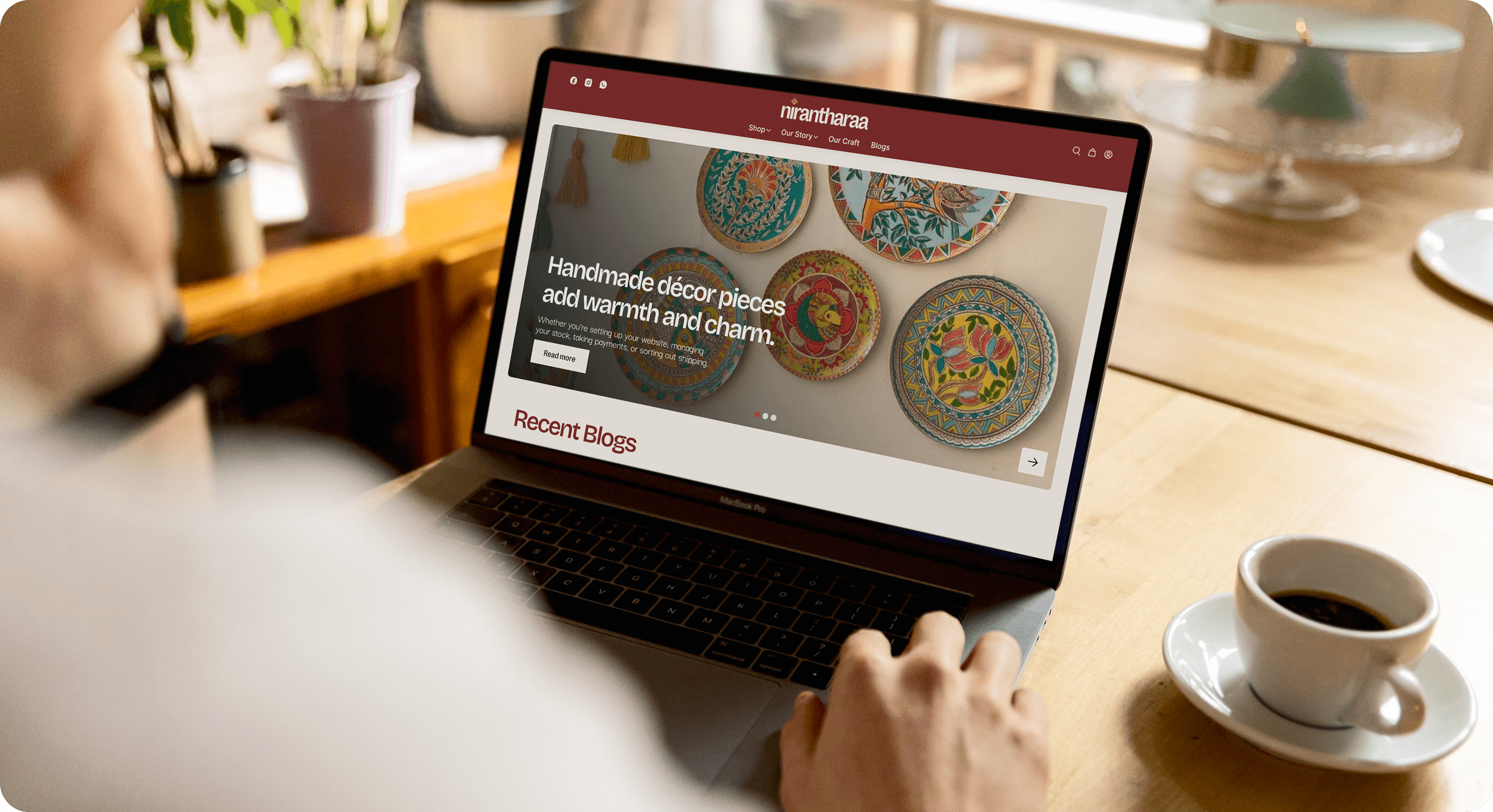 Browsing Nirantharaa online store for handmade Indian home décor and cultural crafts on a laptop.