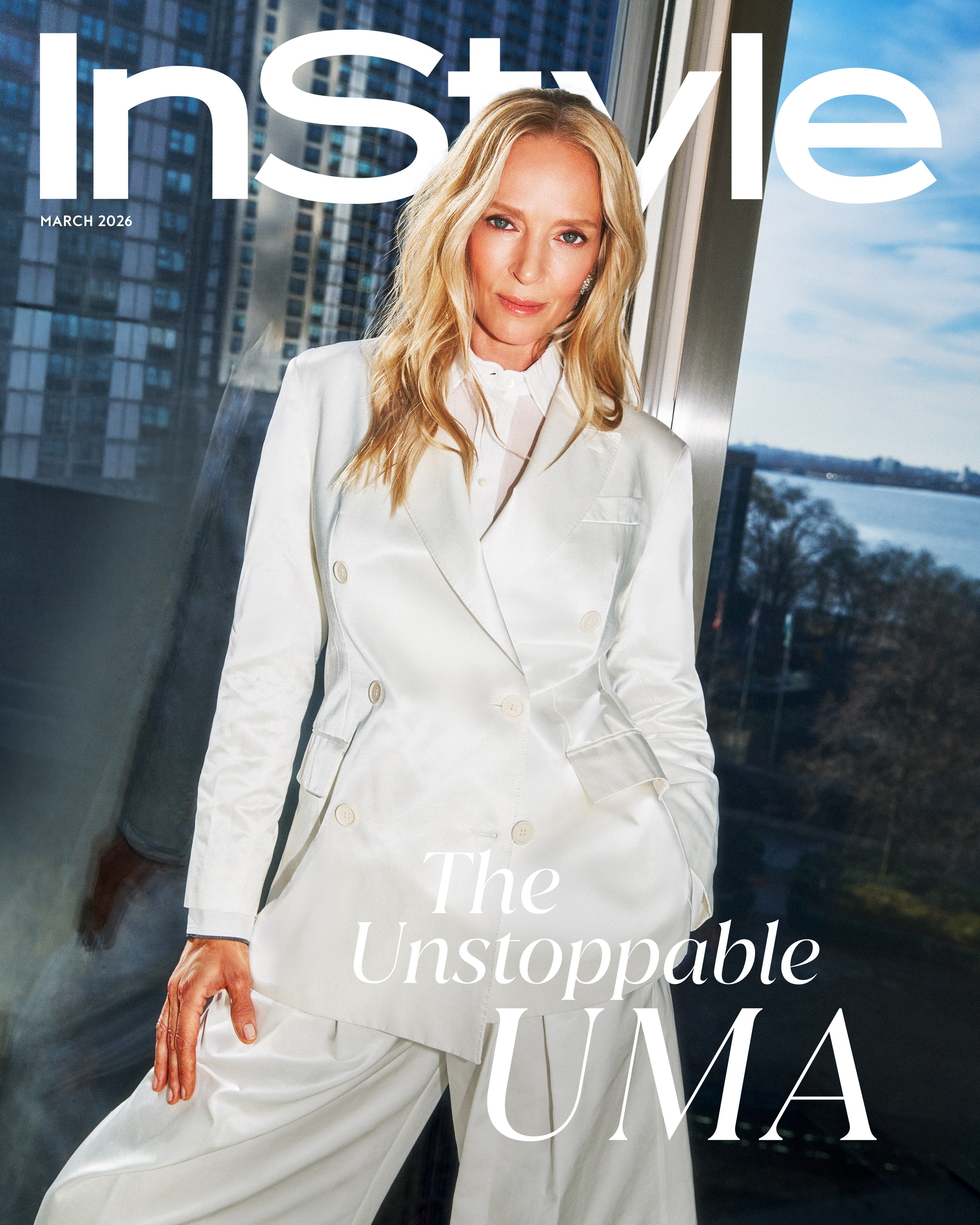 Uma Thurman on the March 2026 cover of InStyle in a white suit before city windows