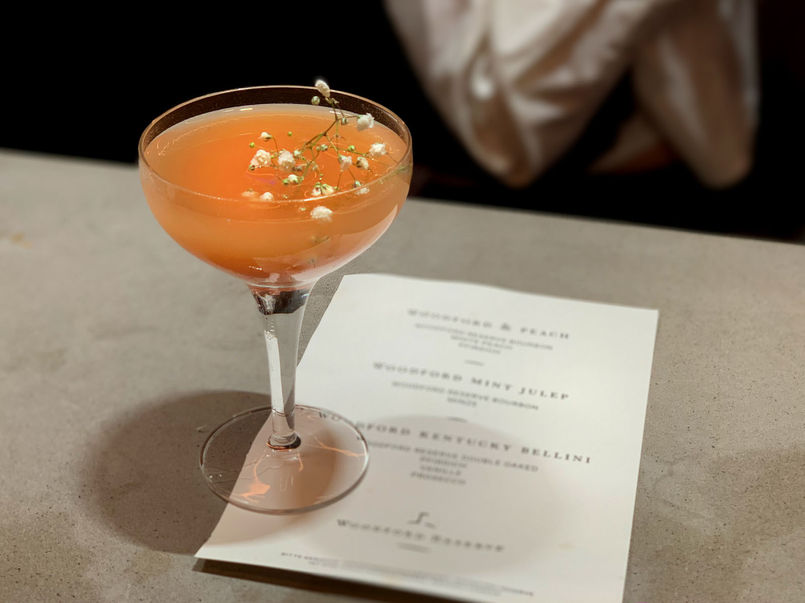 Eleganter Signature Cocktail in Coupe-Glas mit Cocktailkarte