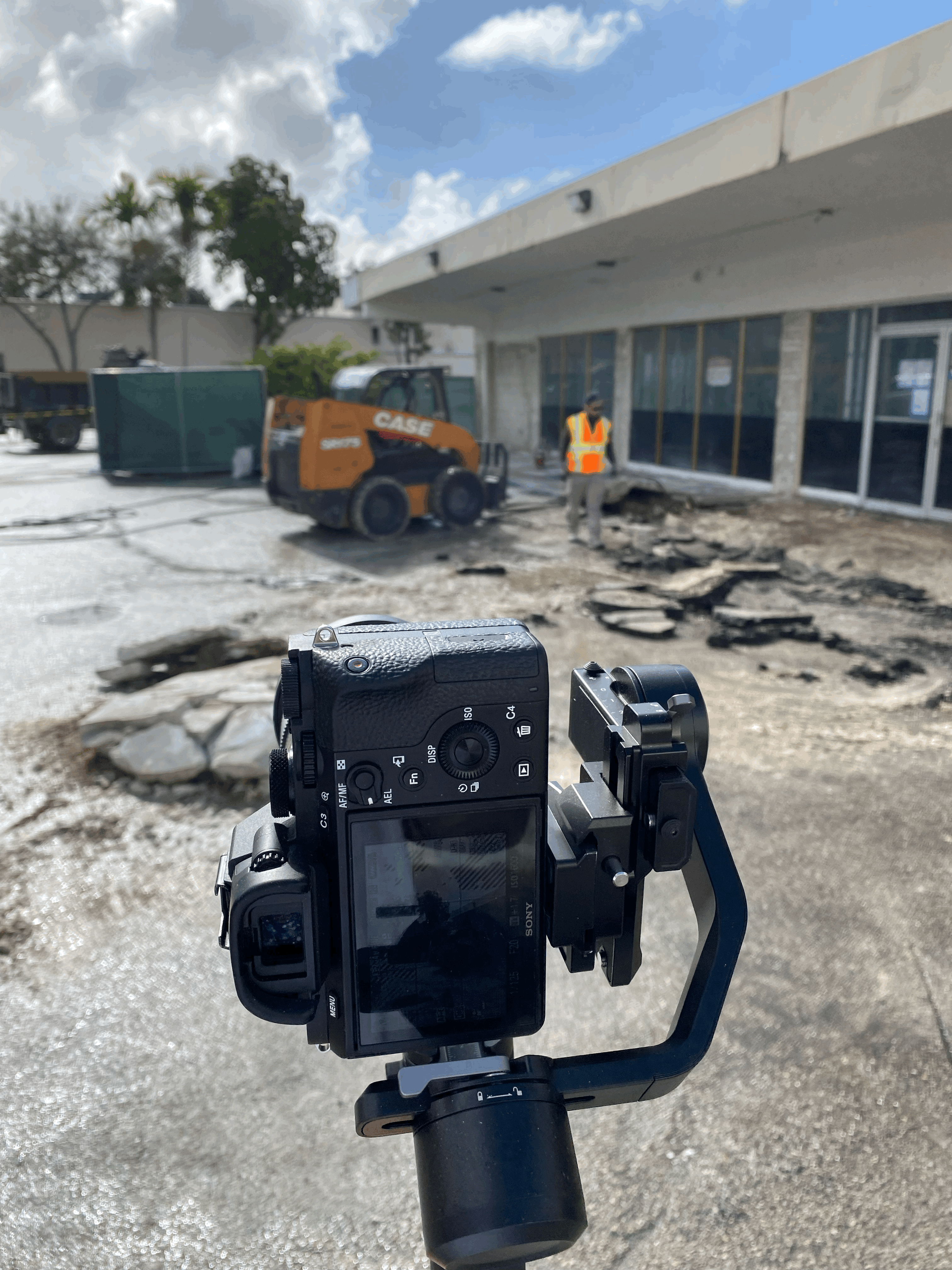 A woman stands in an office, with social media icons emerging from her laptop, symbolizing digital connectivity and engagement.