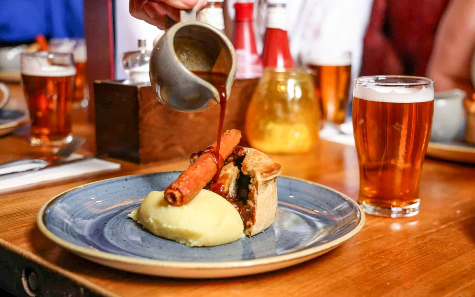 Über Soße auf Pie und Mash gießen und dazu ein Pint Bier auf der Eating London Food-Tour genießen.