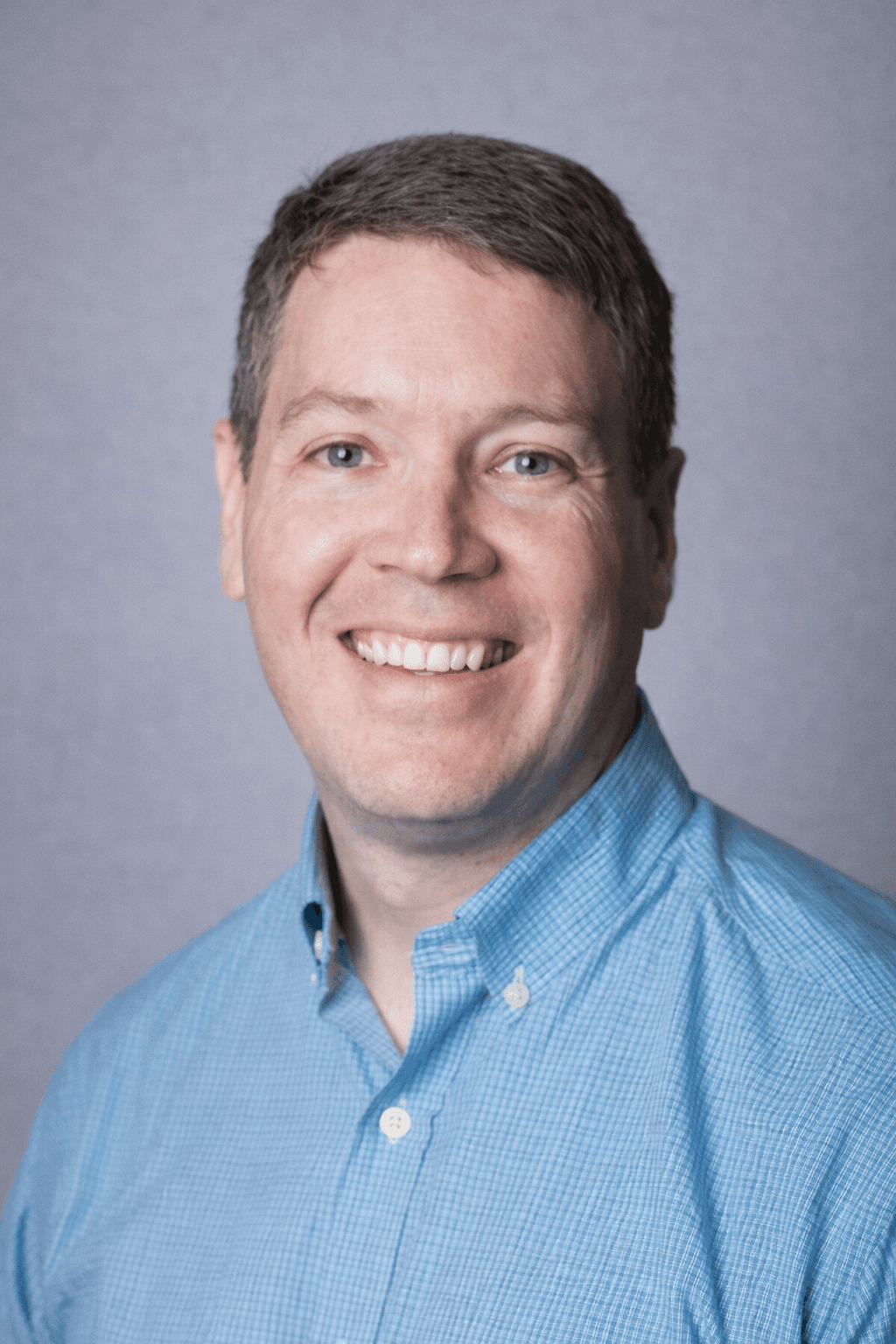 Black and white portrait of a smiling person with curly hair