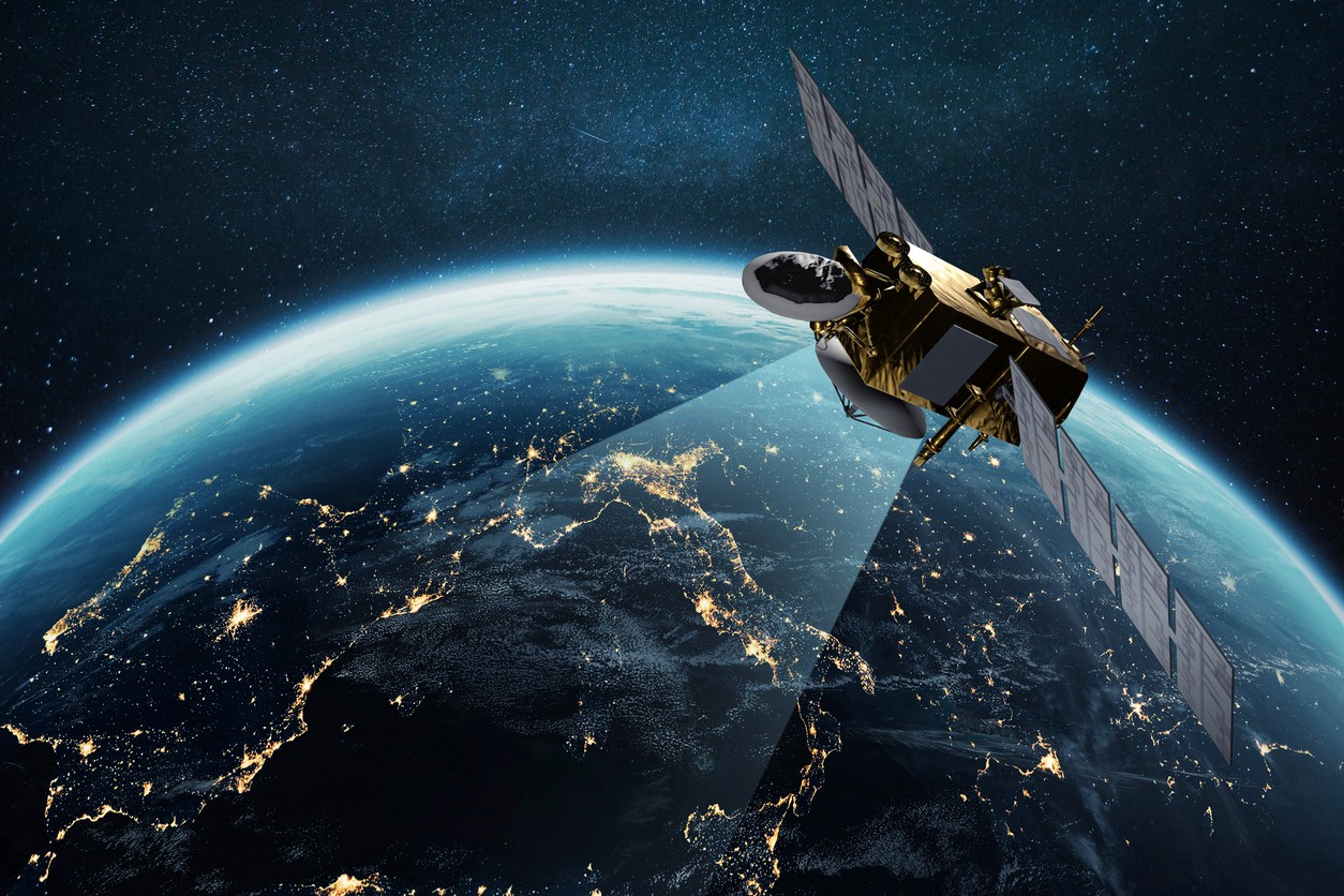 Communications satellite transmitting or collecting data above a nighttime Earth
