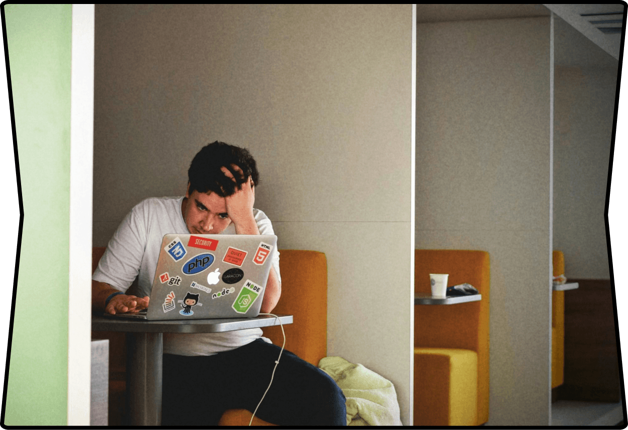 A frustrated man is sitting at a laptop