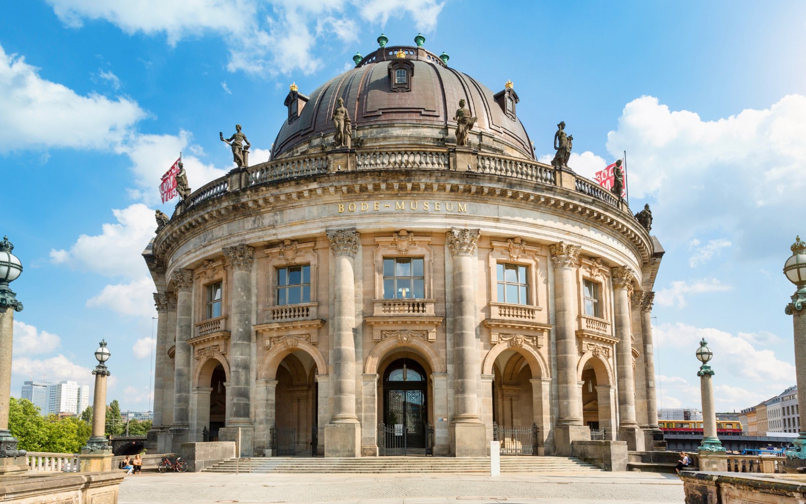 骑行者在柏林的世界遗产博物馆岛探索，背后是历史悠久的建筑。