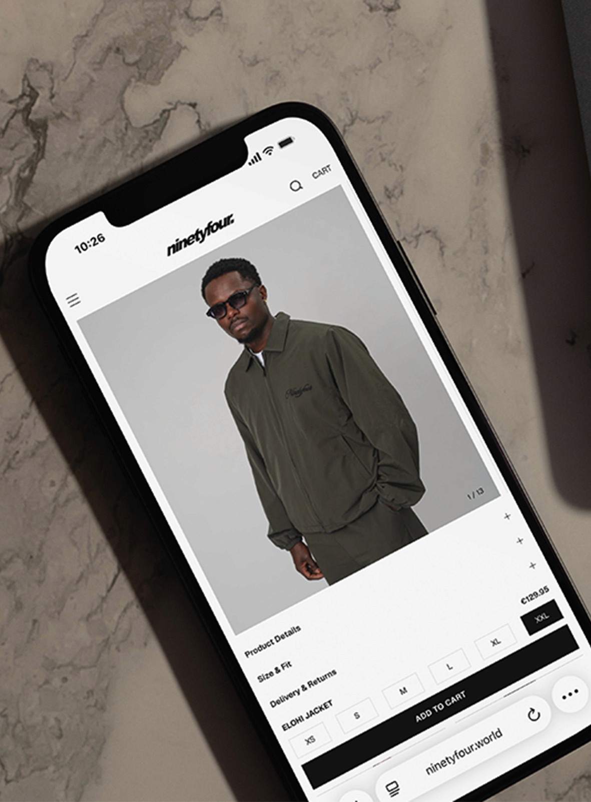 Female athlete in black sports bra arms spread against orange