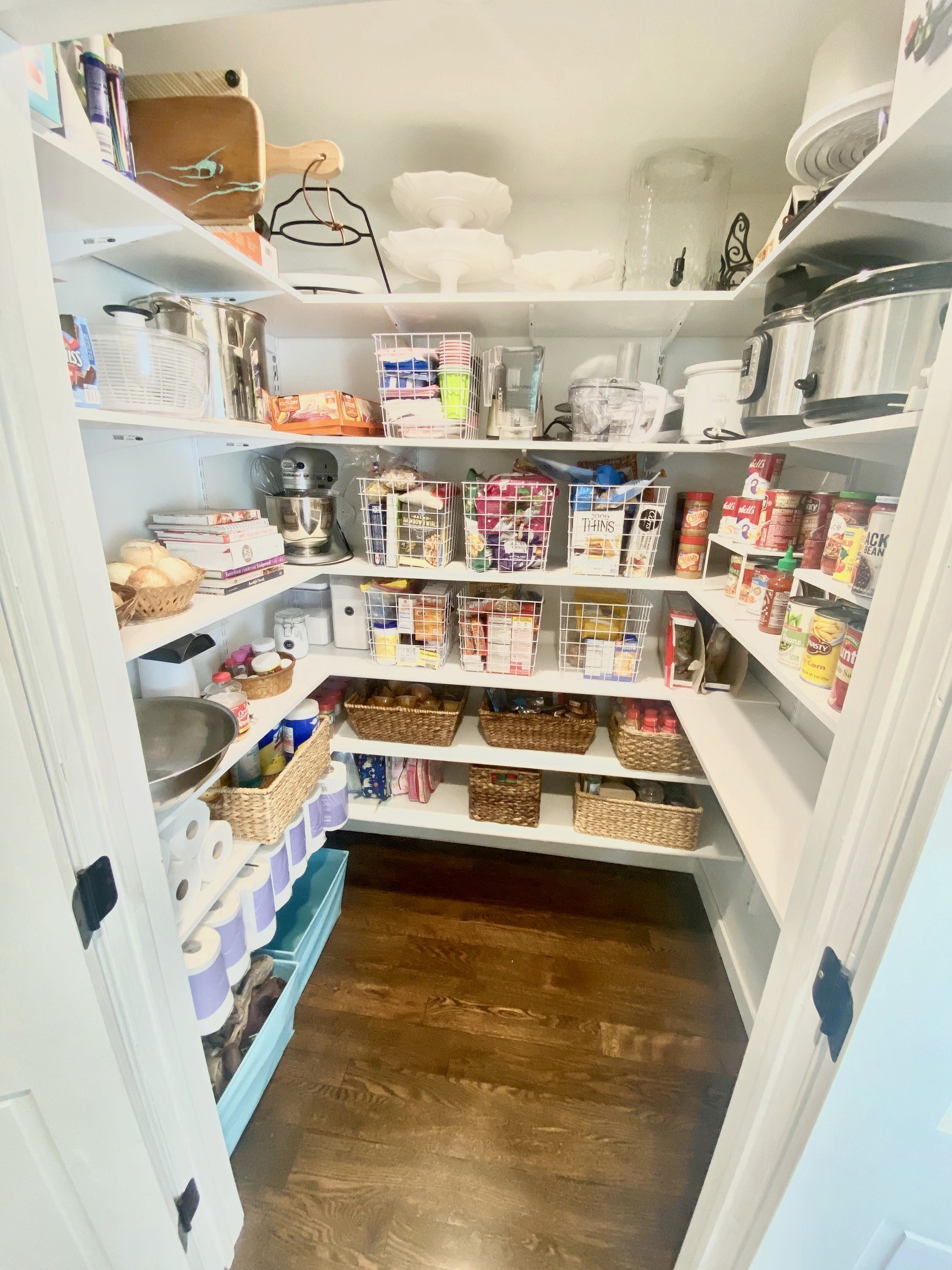 walk in pantry with lots of baskets and cans