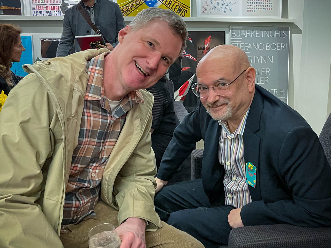 two people sitting at a cocktail party looking at the camera