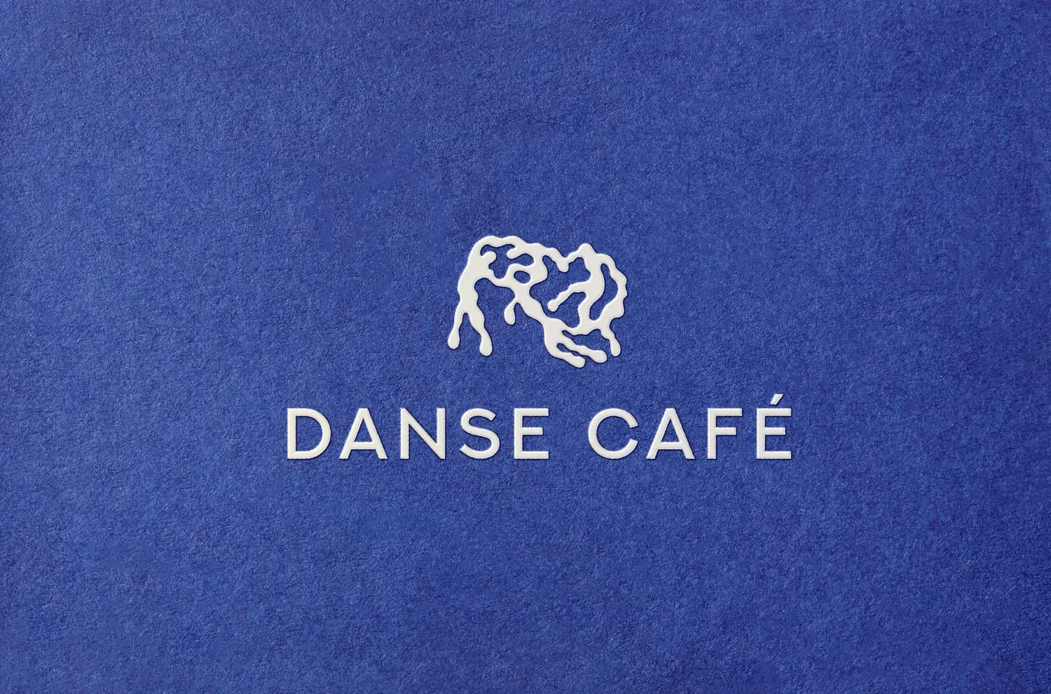 Danse Café logo embossed on cobalt paper