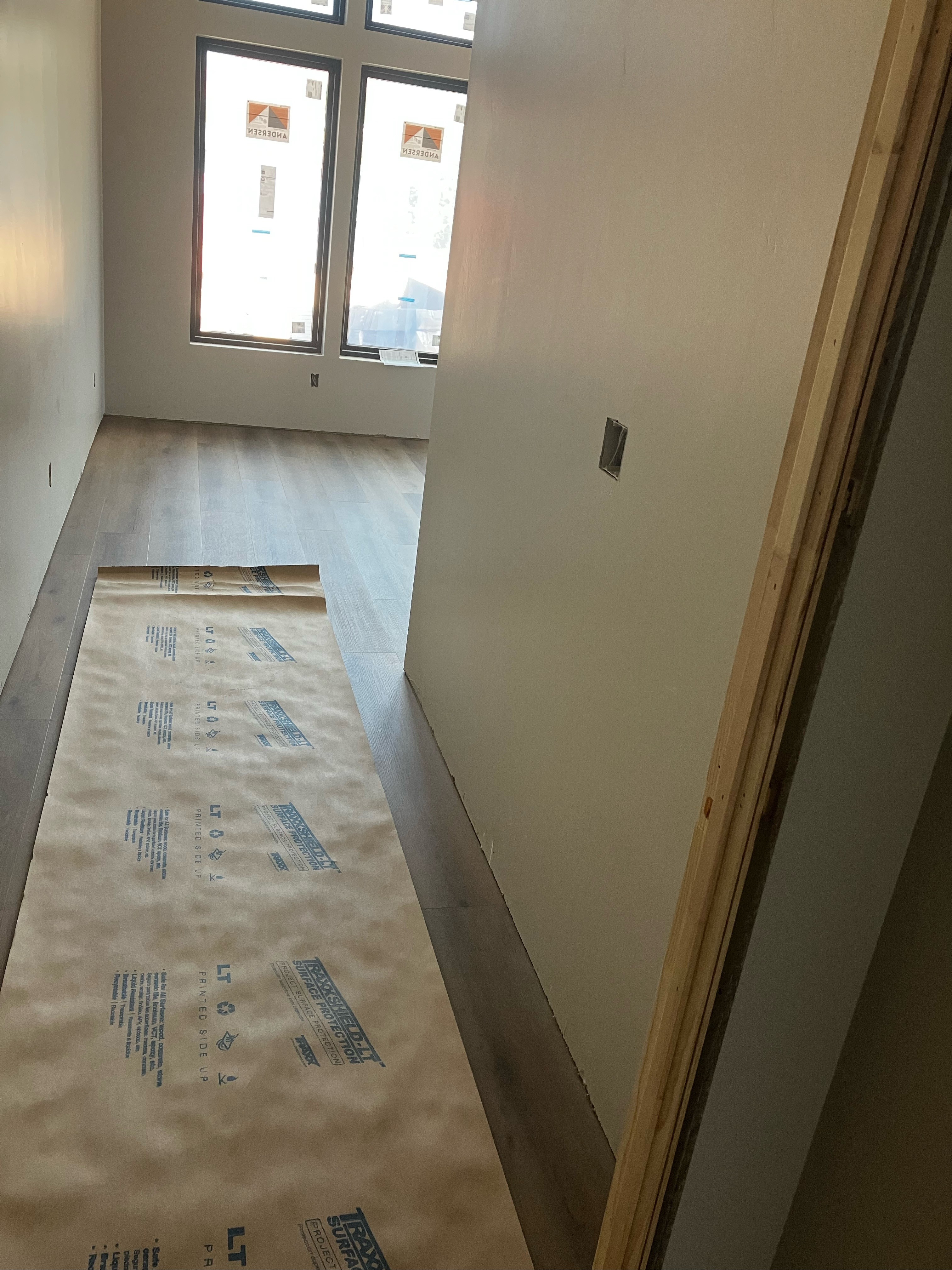 Project update photo of a bedroom with recently laid flooring in a Leeds, Utah home.