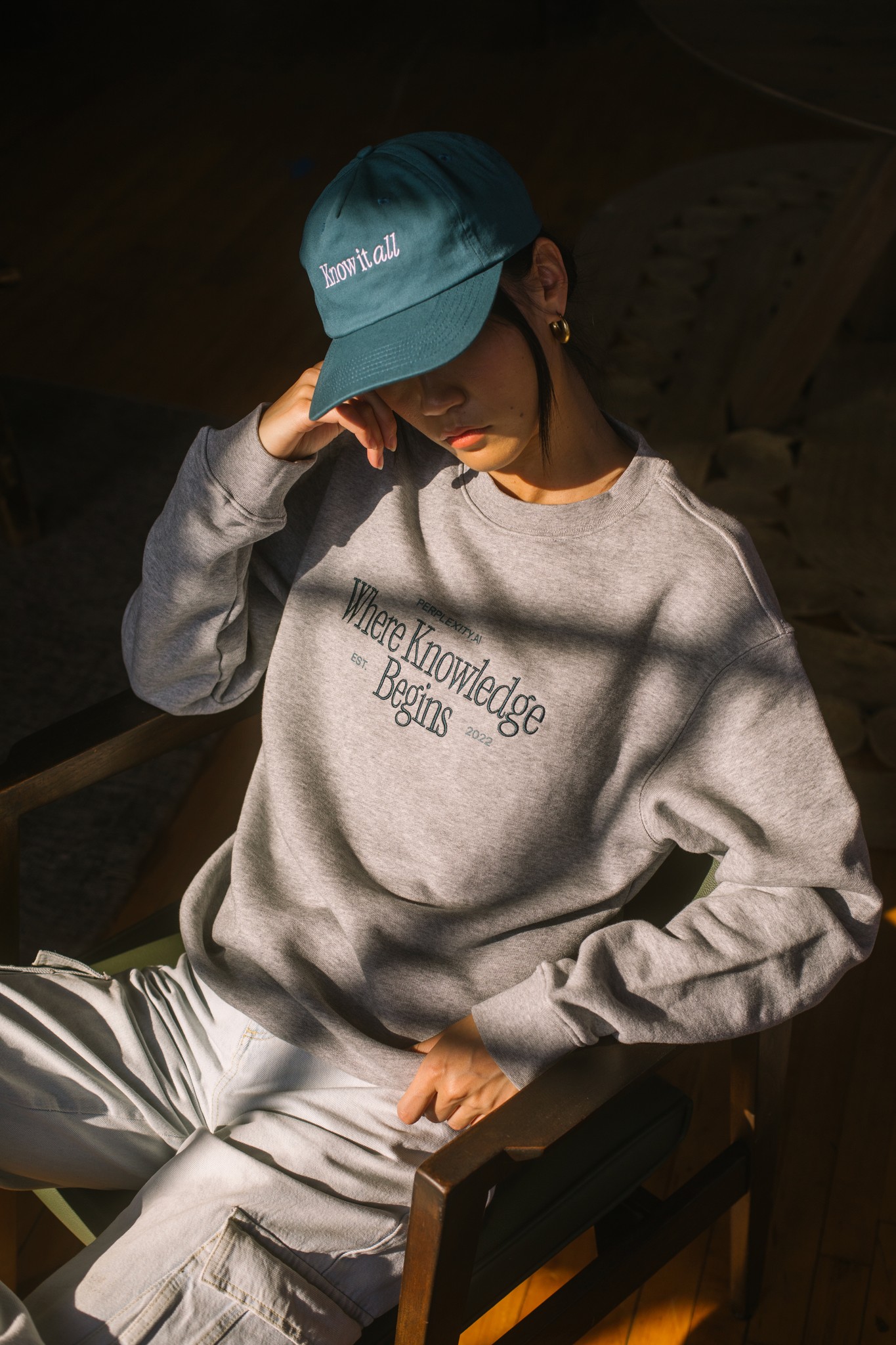 Woman in sweatsuit standing against wood wall