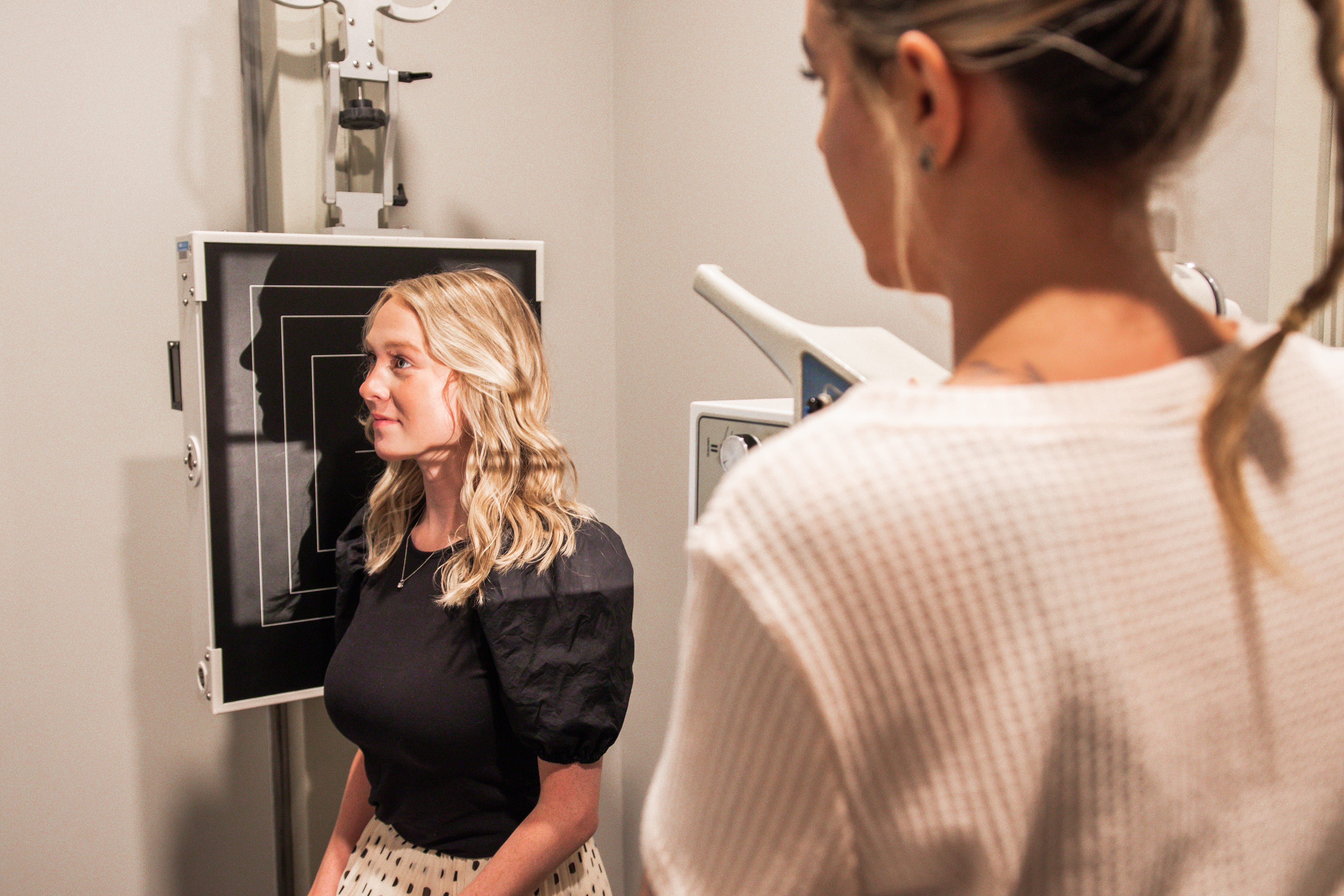 A female client receiving scans in an exam room.