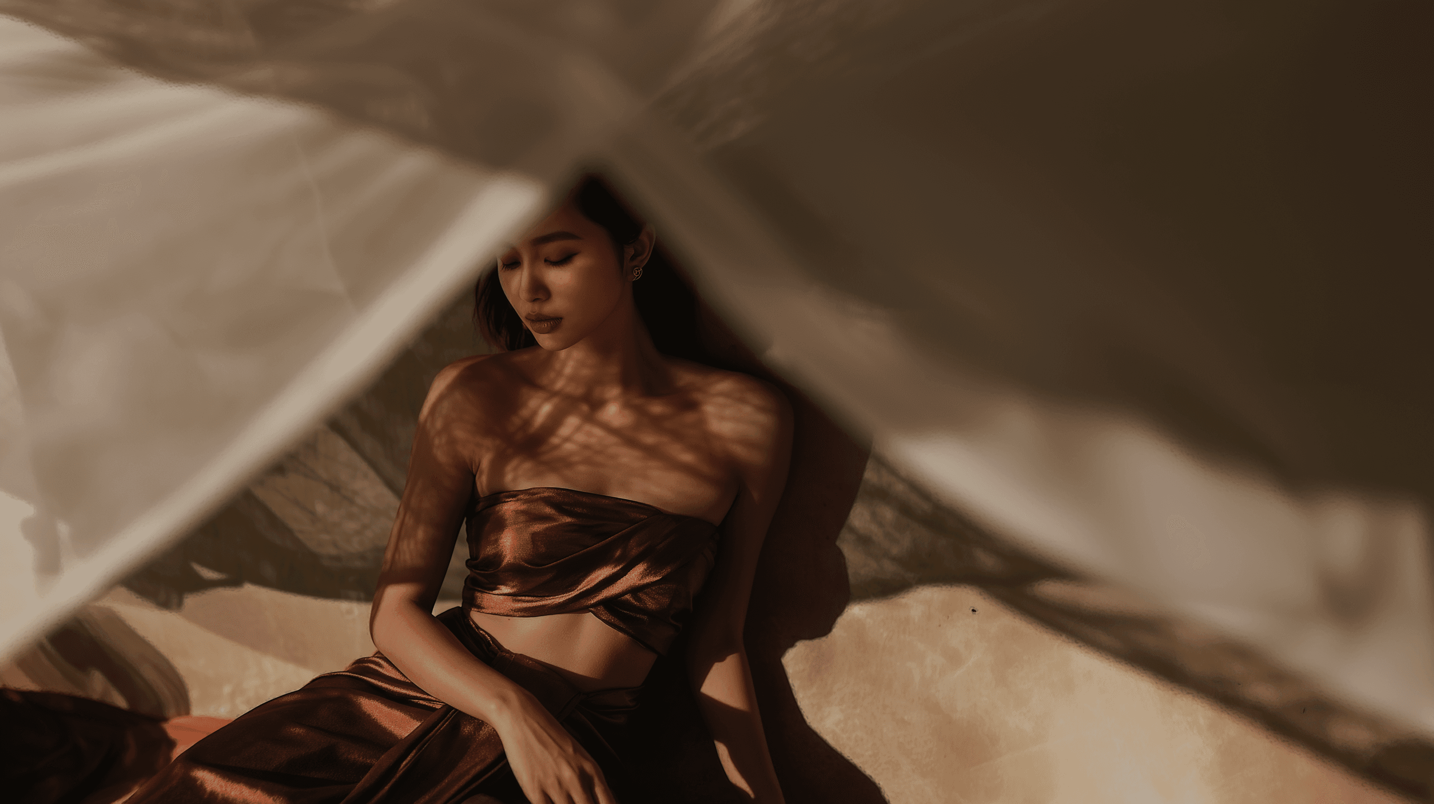 Elegant woman resting in dappled sunlight at an exclusive adult-only sanctuary in Bangkok, opening April 2026 for private sensory therapy appointments.