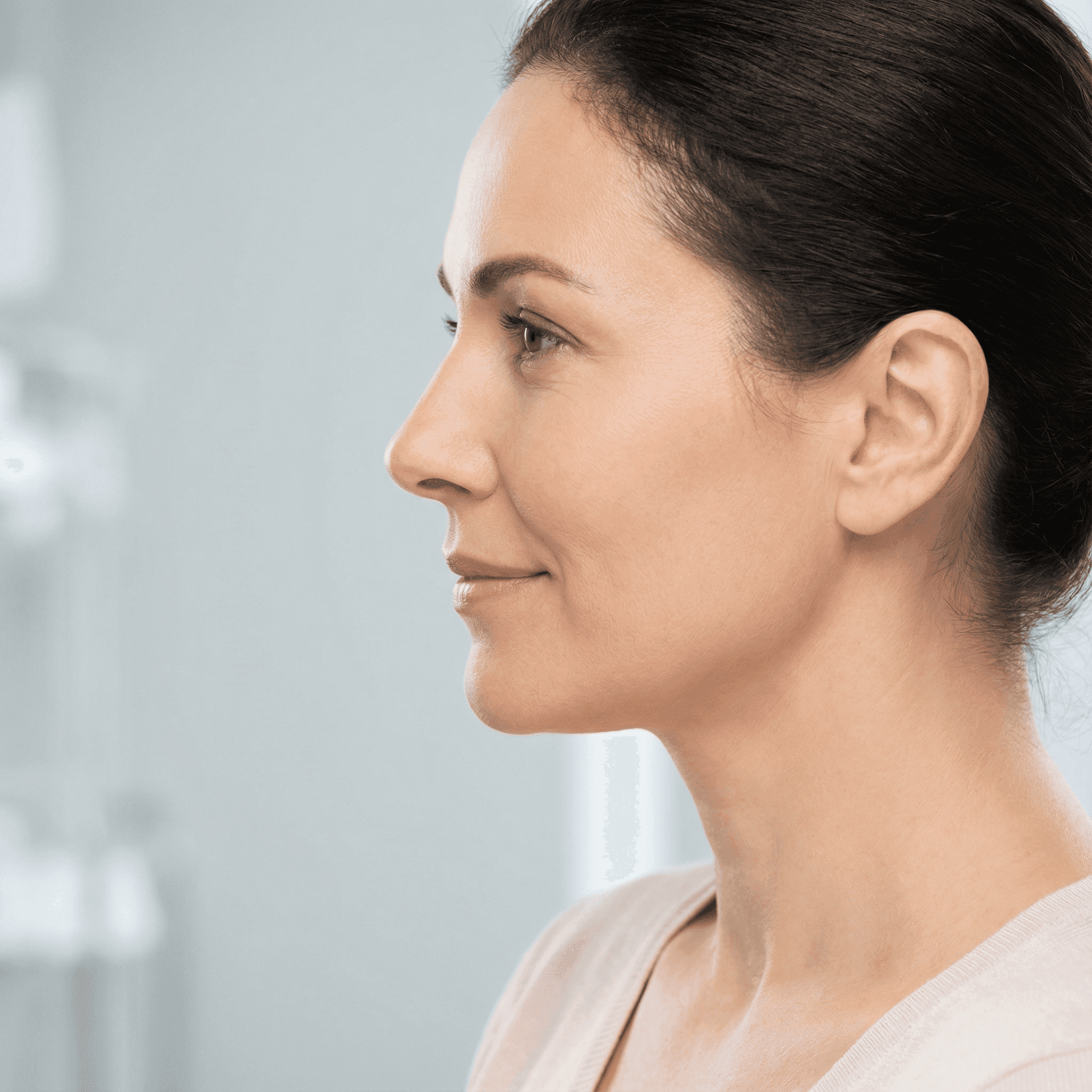 Invisalign in Dubai with a woman smiling confidently, holding her clear aligners, highlighting discreet and effective treatment.