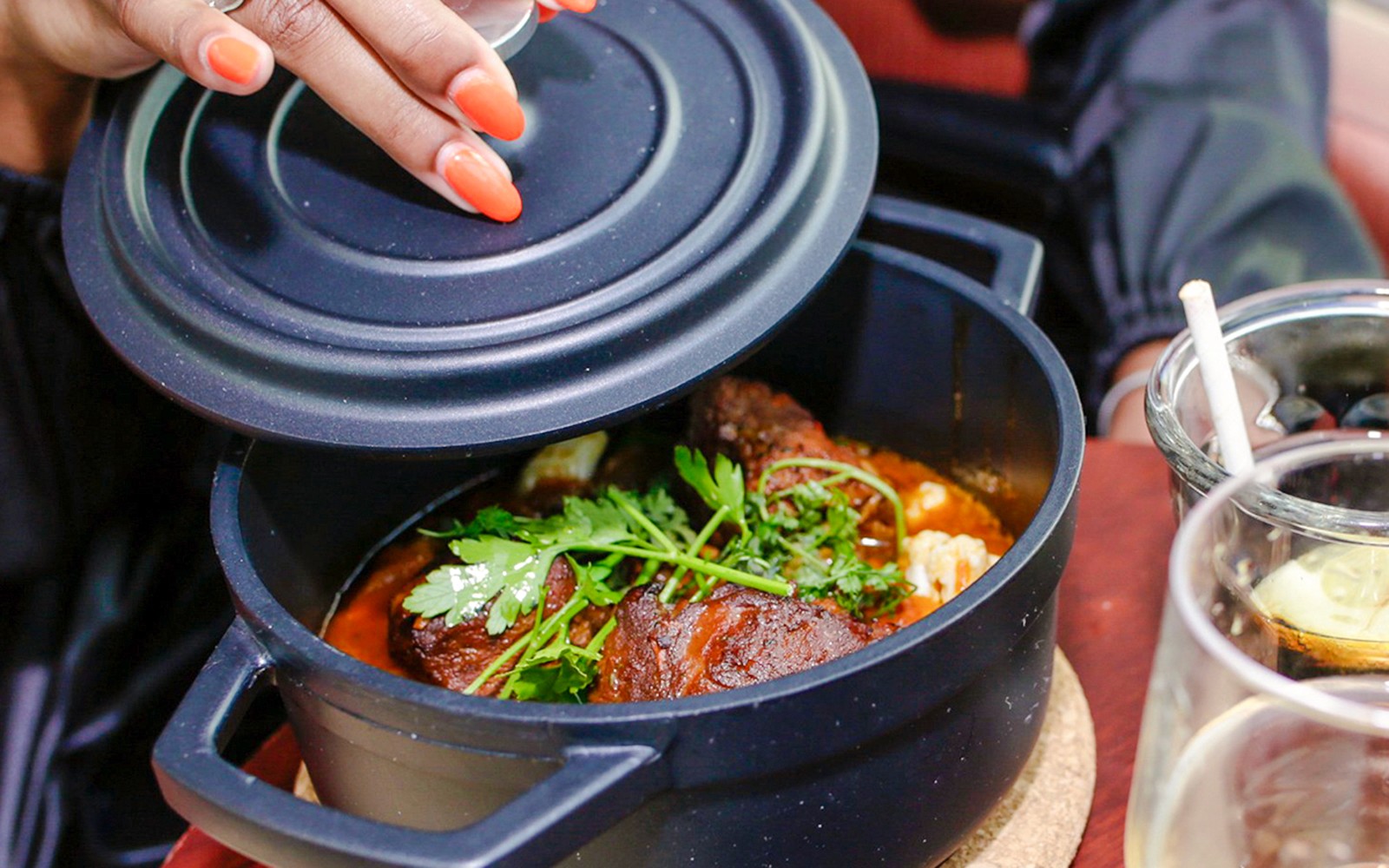 在巴黎塞纳河的“巴黎现场晚餐巡游”上，有人正在揭开一道菜的盖子。