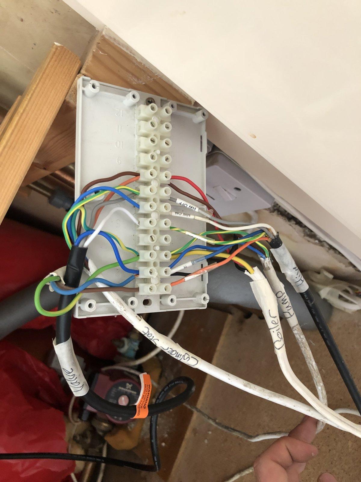 Heat pump control wiring terminals inside a UK heating system showing incorrectly connected control wire causing constant heating demand