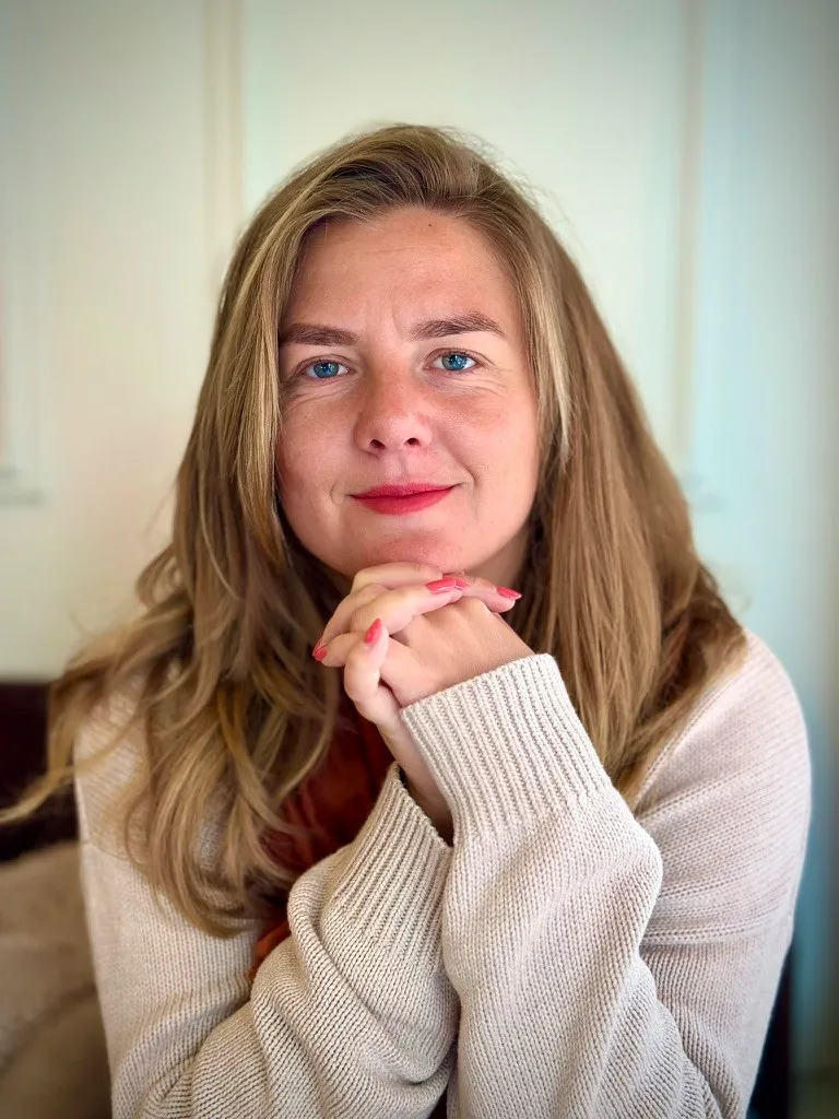 Roos van der Burg, oprichtster van SheVibes, kijkt warm en krachtig in de camera met haar handen onder haar kin