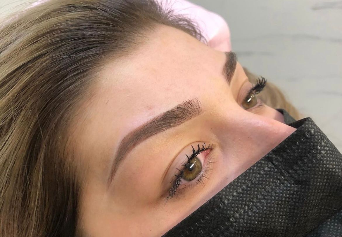 A girl with a beautiful smile stands at the reception in the Camelia beauty salon, awaiting visitors.