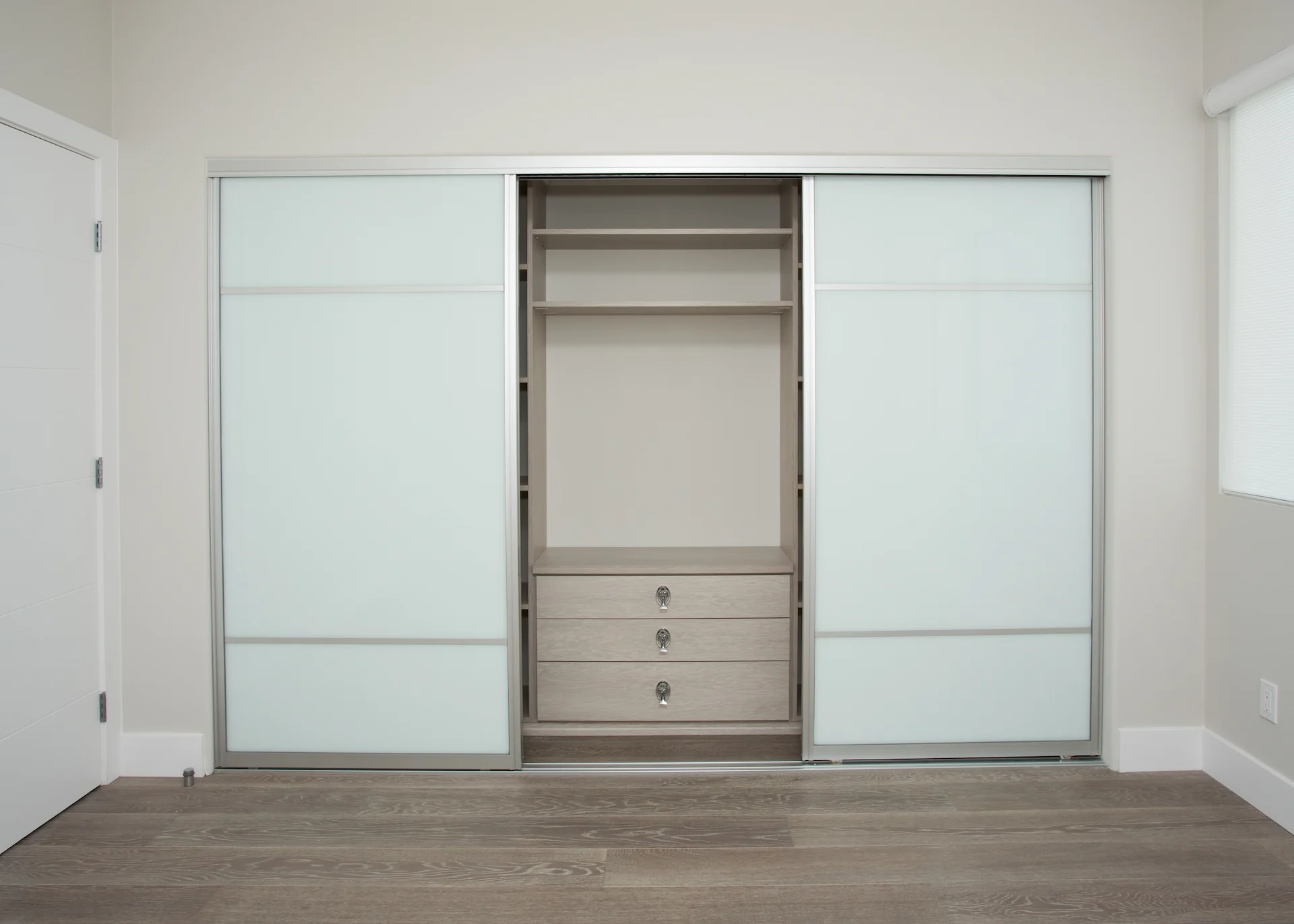View of the 1st guest bedroom's sliding closet, a practical and stylish storage solution in this modern Newport Beach home.