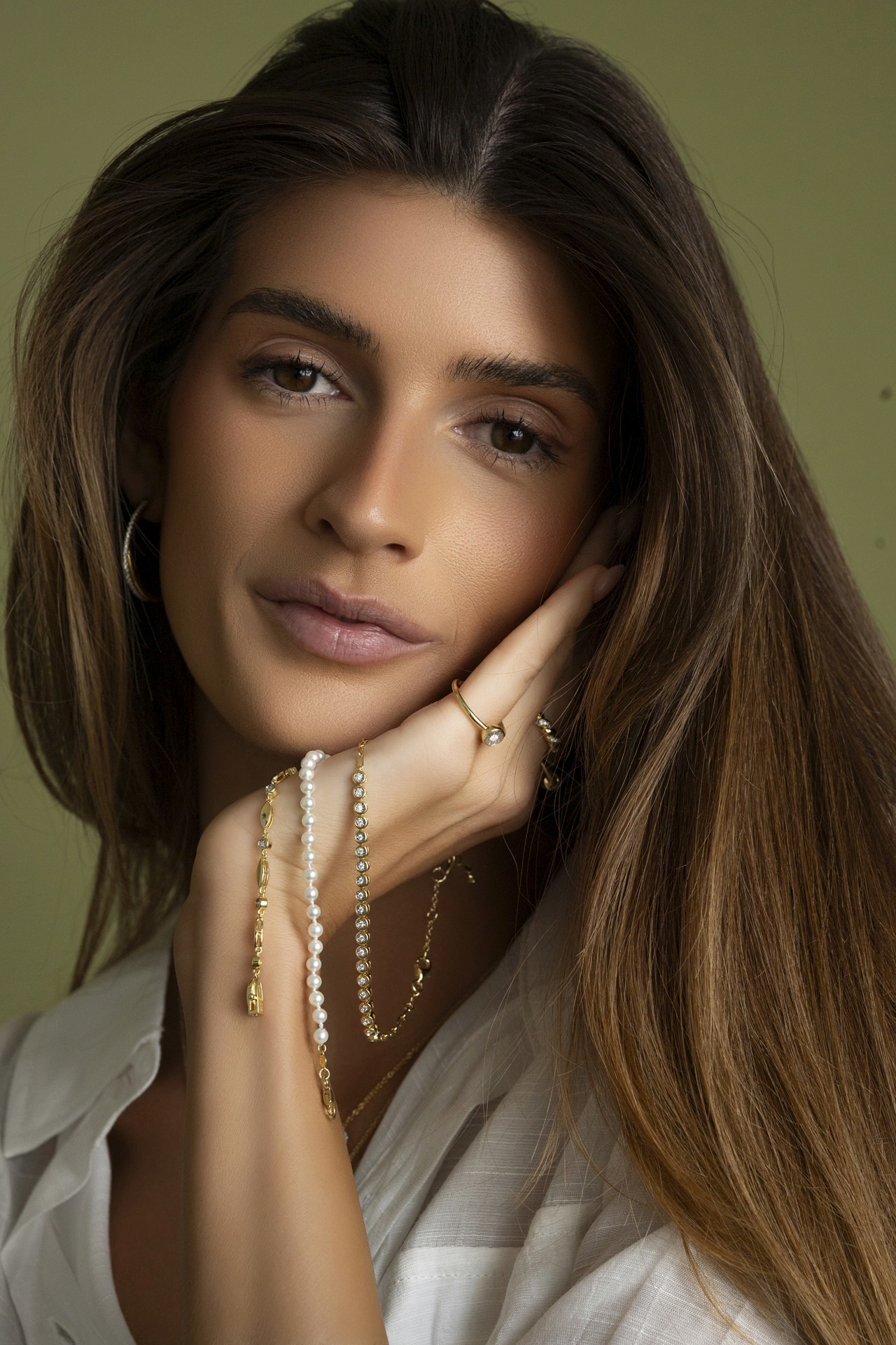 fashion photography of a model wearing a variety of bracelets on her wrist, in a spring-like editorial setting, photographed in DFW.