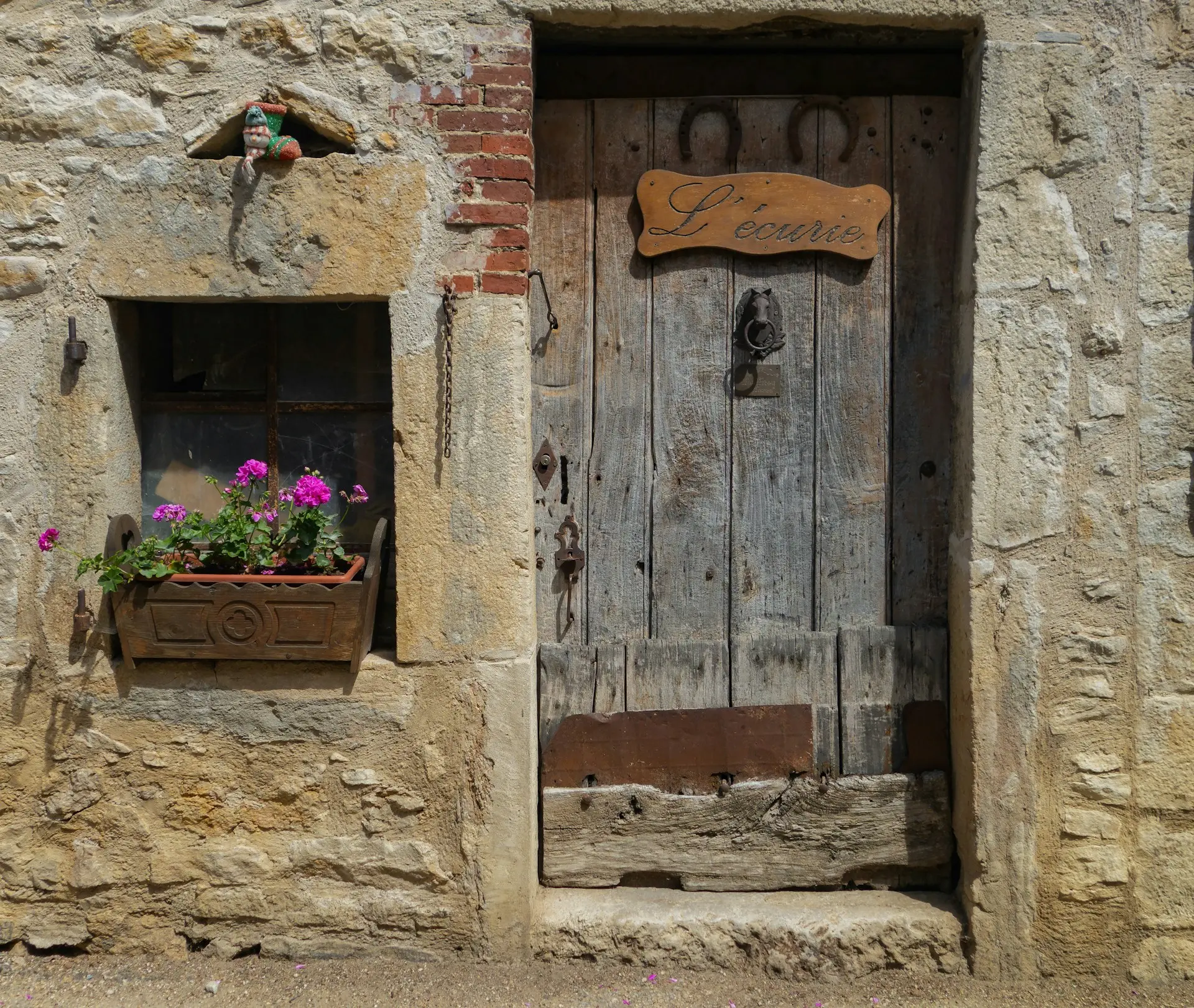 An old wooden door, adorned with flowers and forgotten tales – a silent invitation to step into the past.