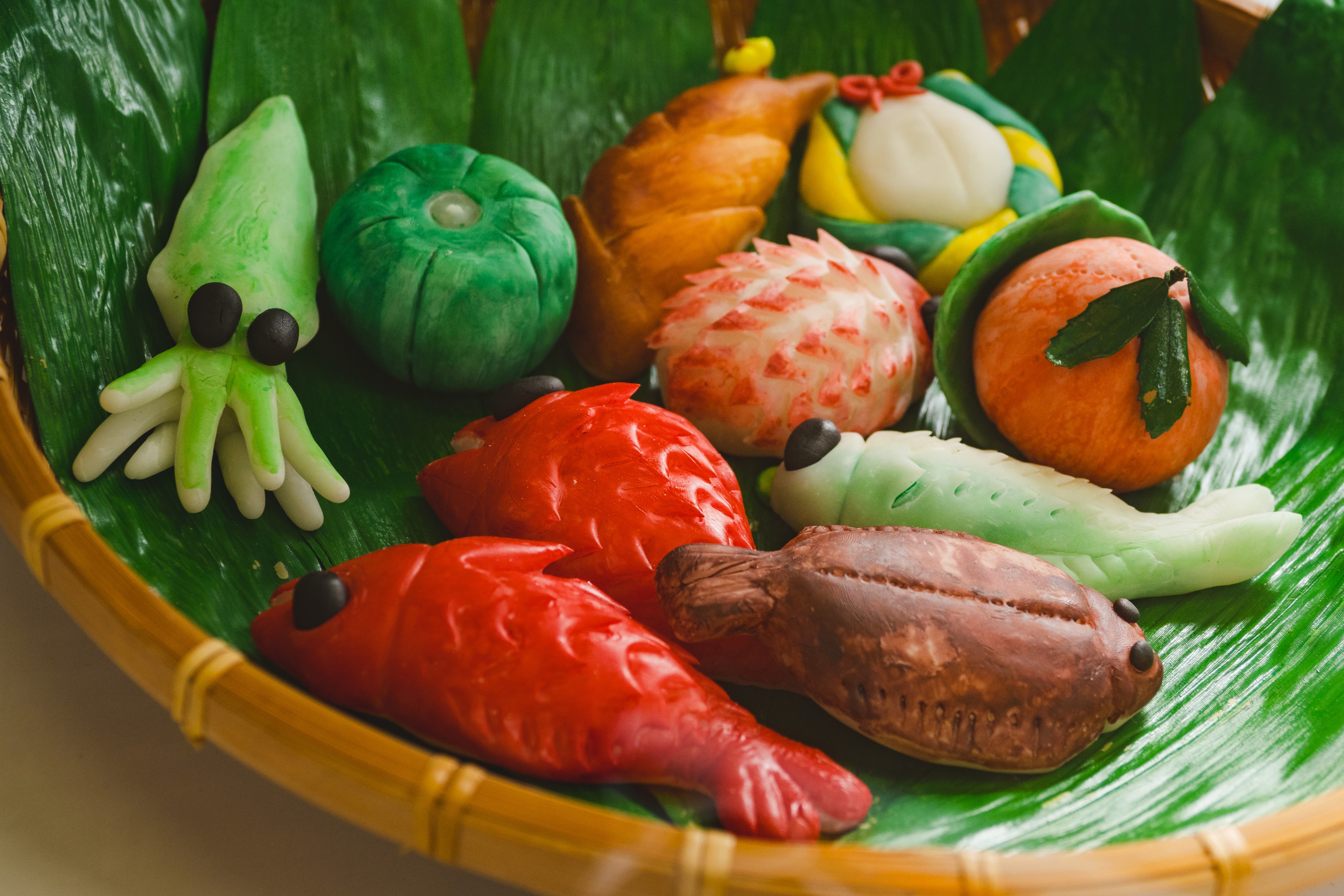 Close-up of colorful Japanese wagashi shaped like tiny animals and plants