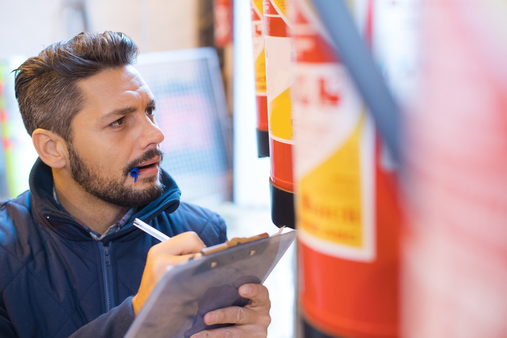 man checking a fire extinguisher