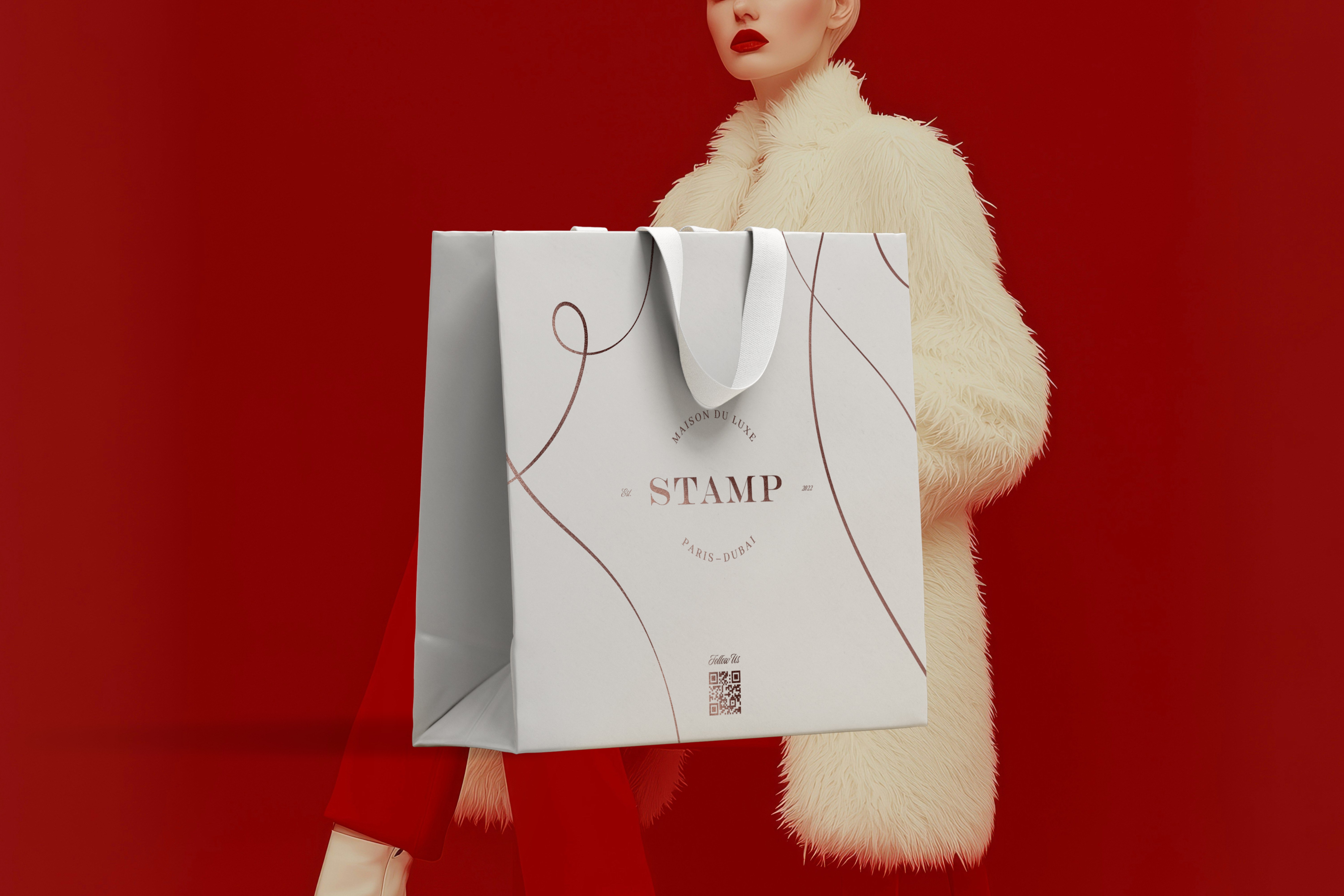 A chic, high-end shopping bag with STAMP branding, held by a model in a white fur coat, creating a striking contrast with the red background.