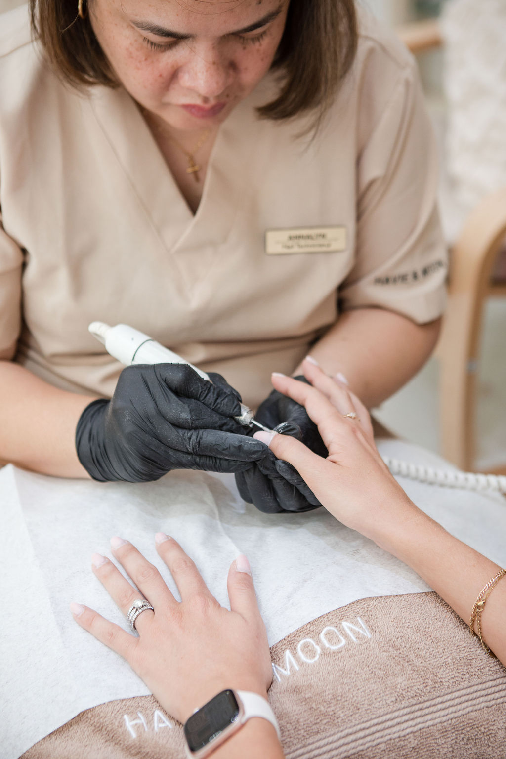 Professional nail technician performing manicure at Havie & Moon salon in Dubai Hills